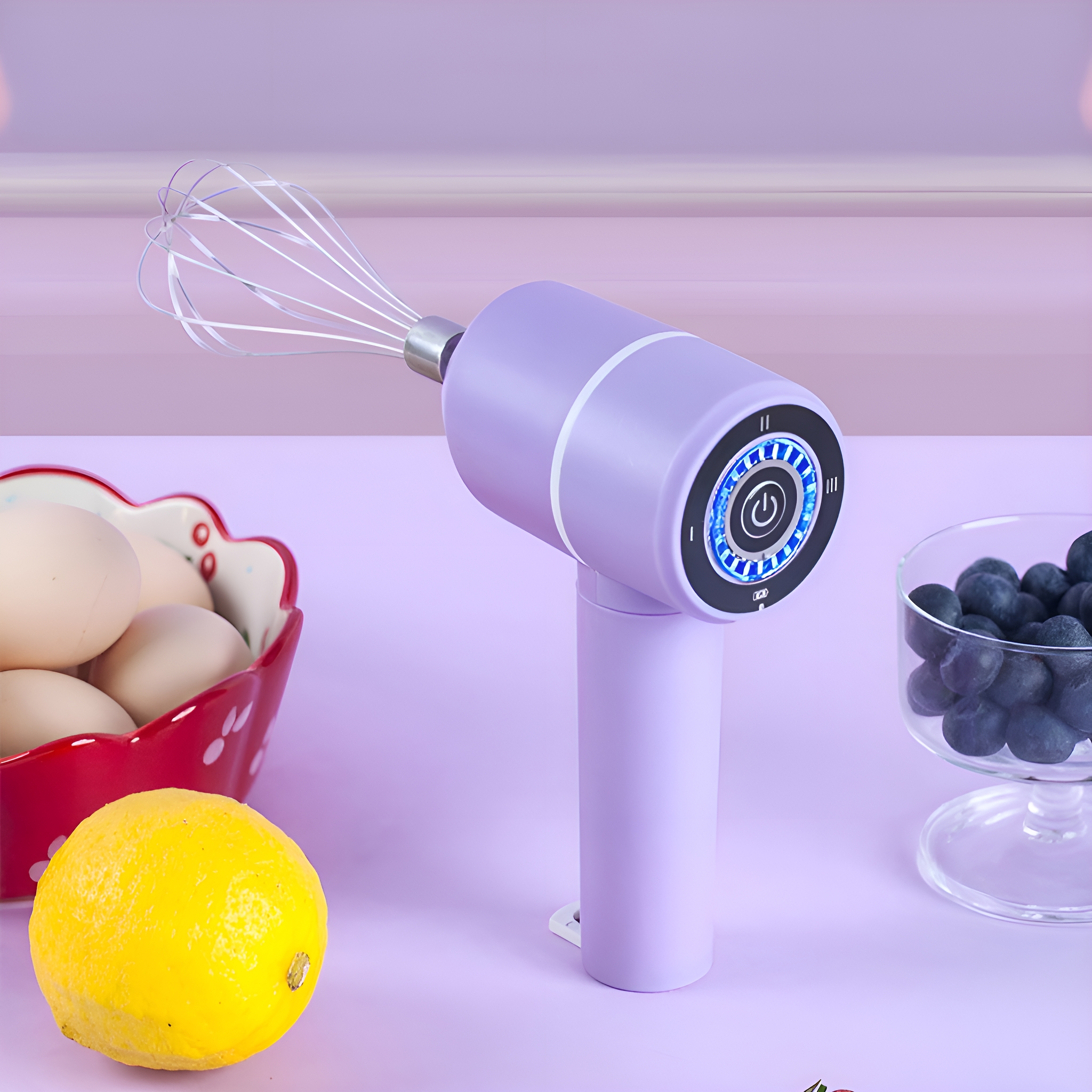 Ein lila Handmixer mit Schneebesen, Eiern, Blaubeeren und Zitrone auf rosa Oberfläche.