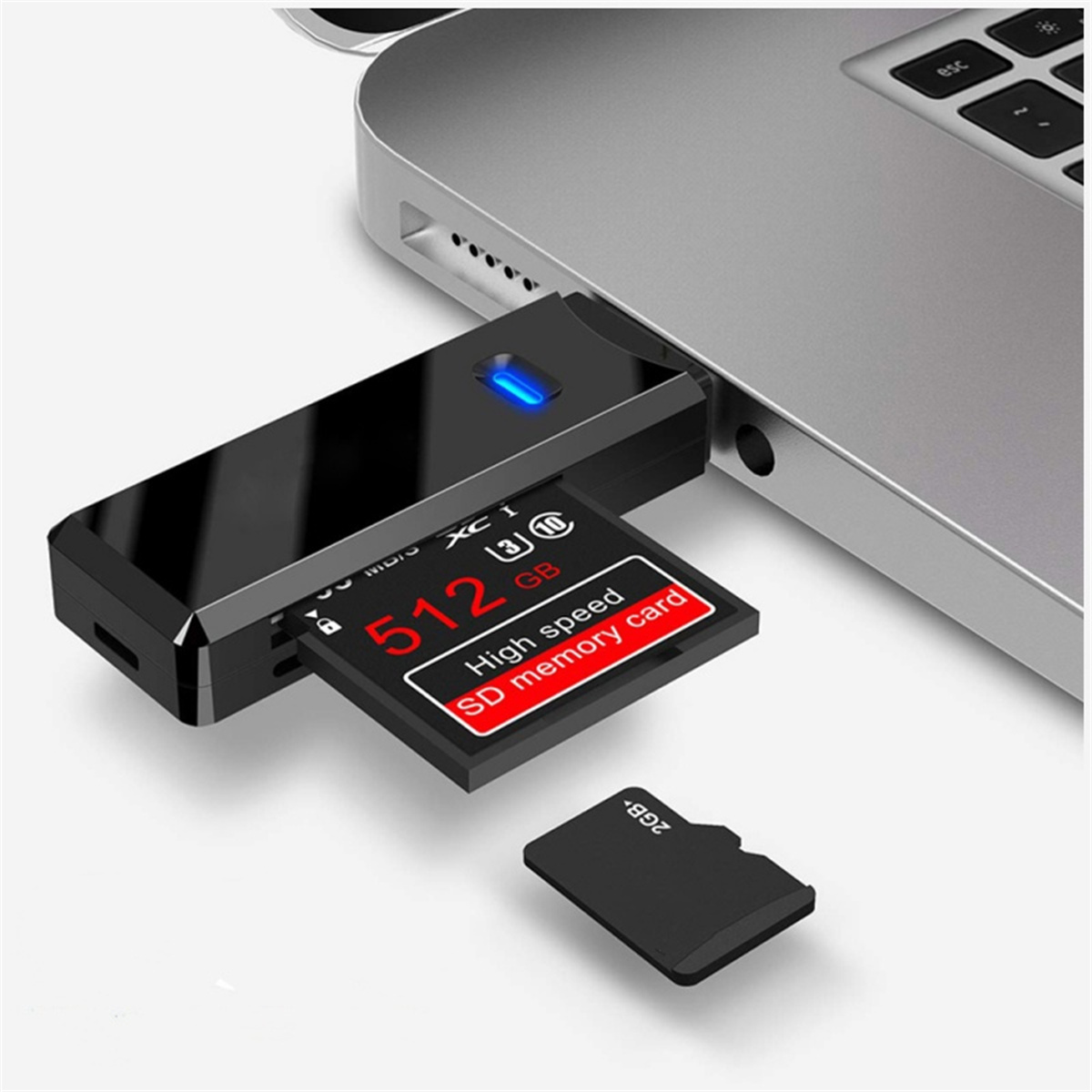 Ein schwarzer SD-Kartenleser, der mit einem Laptop verbunden ist. Eine 512GB SD-Karte ist eingelegt. Eine kleinere SD-Karte liegt daneben.