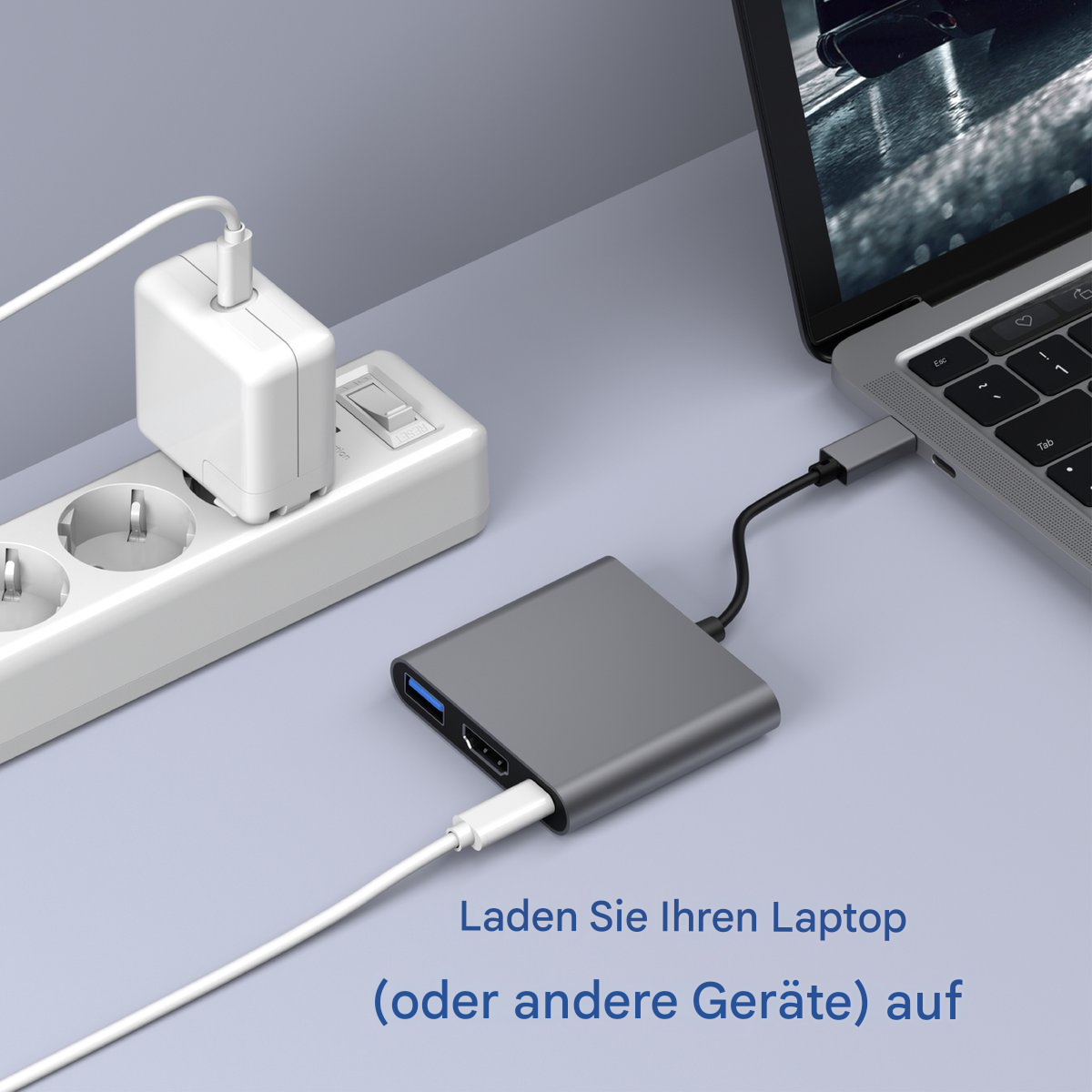Ein Laptop, der mit einem silbernen Hub verbunden ist, mit einem Netzteil in der Wand.