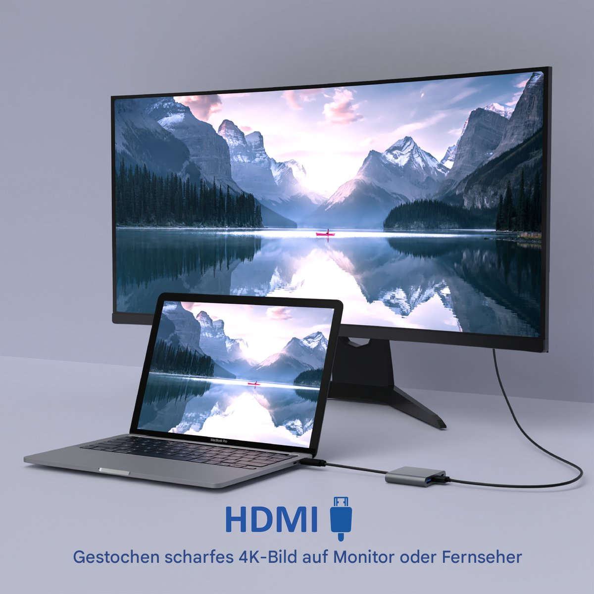 Ein Laptop, der über ein Kabel mit einem Monitor verbunden ist. Der Monitor zeigt eine Landschaft, und ein Laptop steht auf einem Tisch.