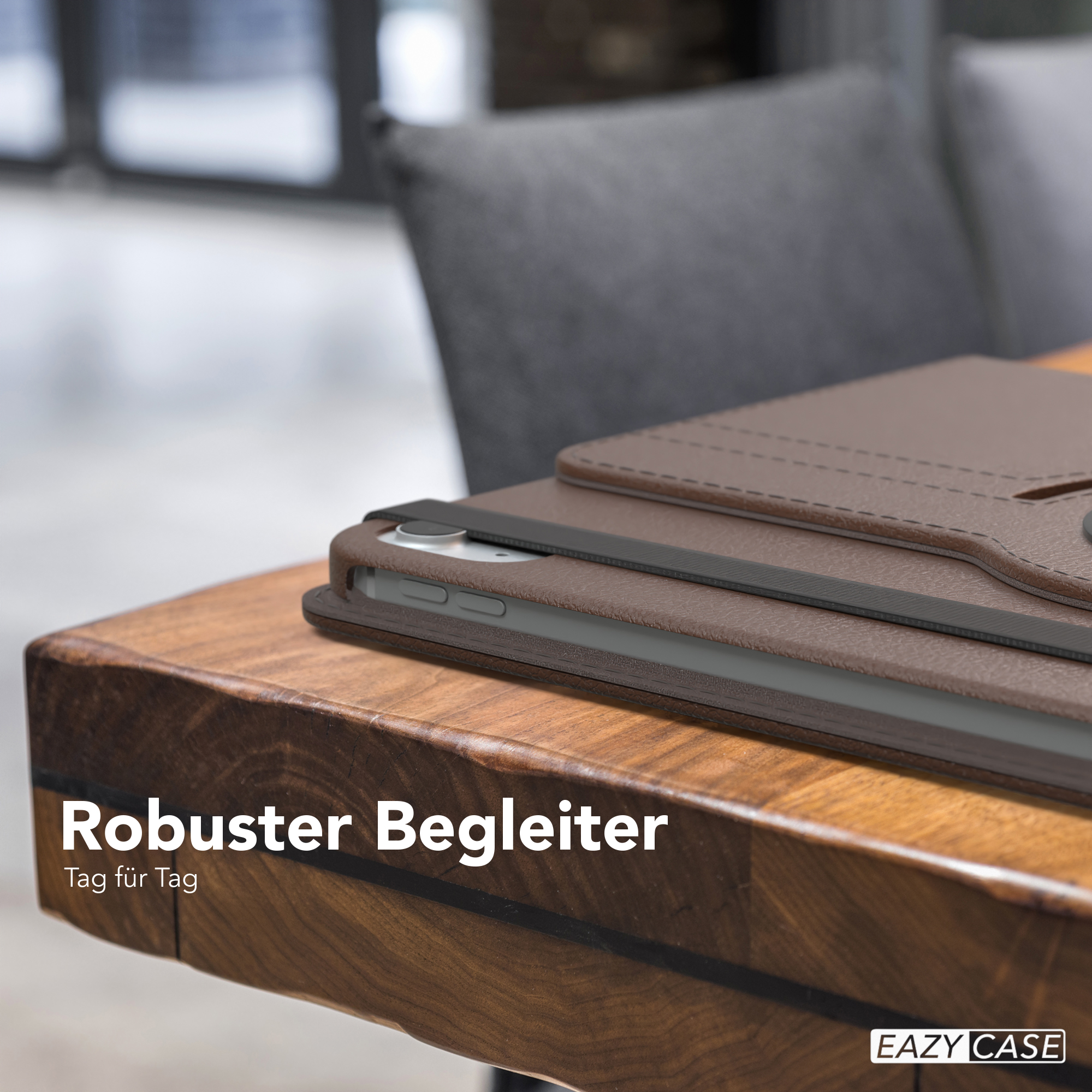 Eine braune Ledertasche mit einem Tablet auf einem Holztisch, mit dem Text: Robuster Begleiter.