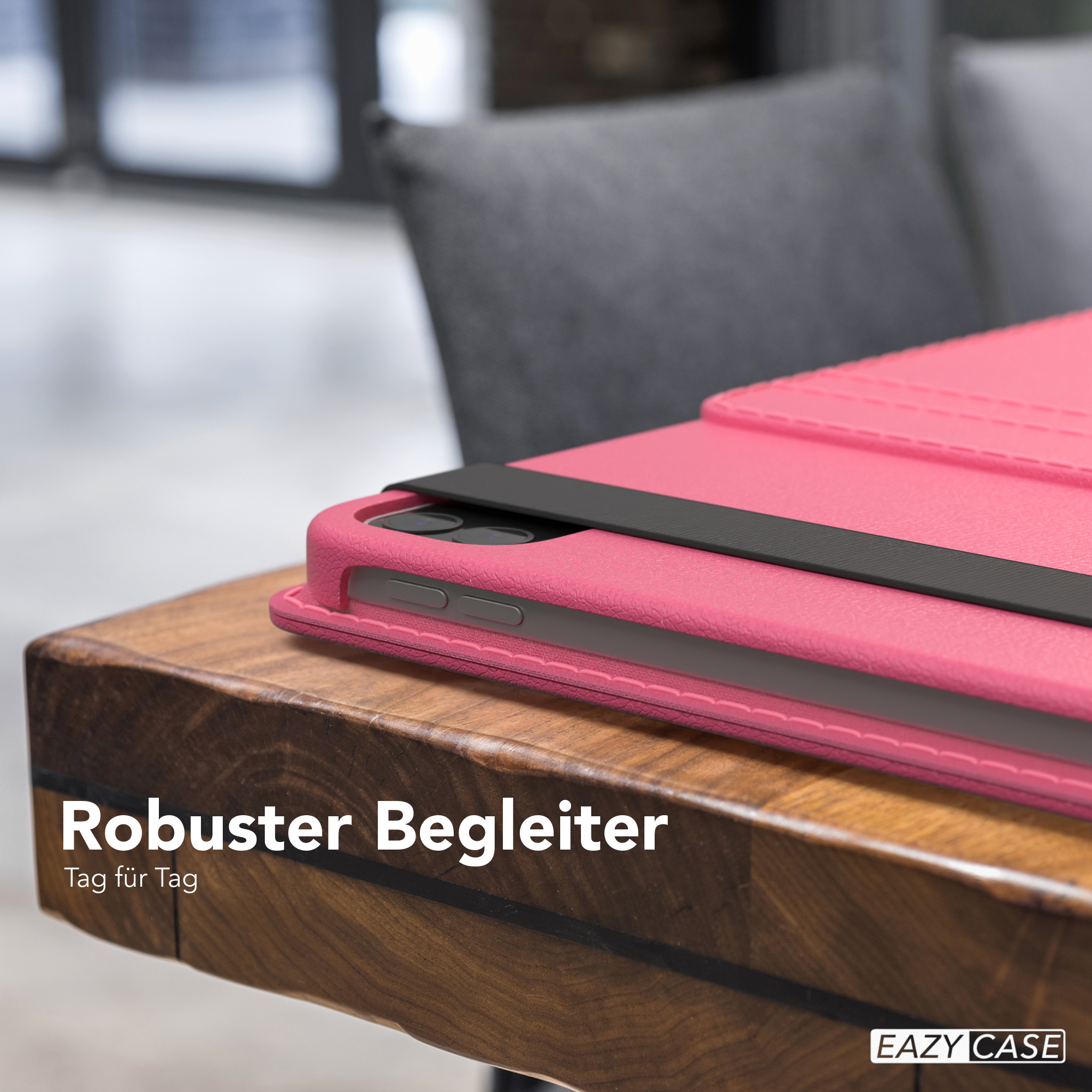 Eine pinkfarbene Tablethülle auf einem Holztisch. Ein schwarzes Band hält das Tablet. Der Text lautet 'Robuster Begleiter', mit dem EAZY CASE-Logo.