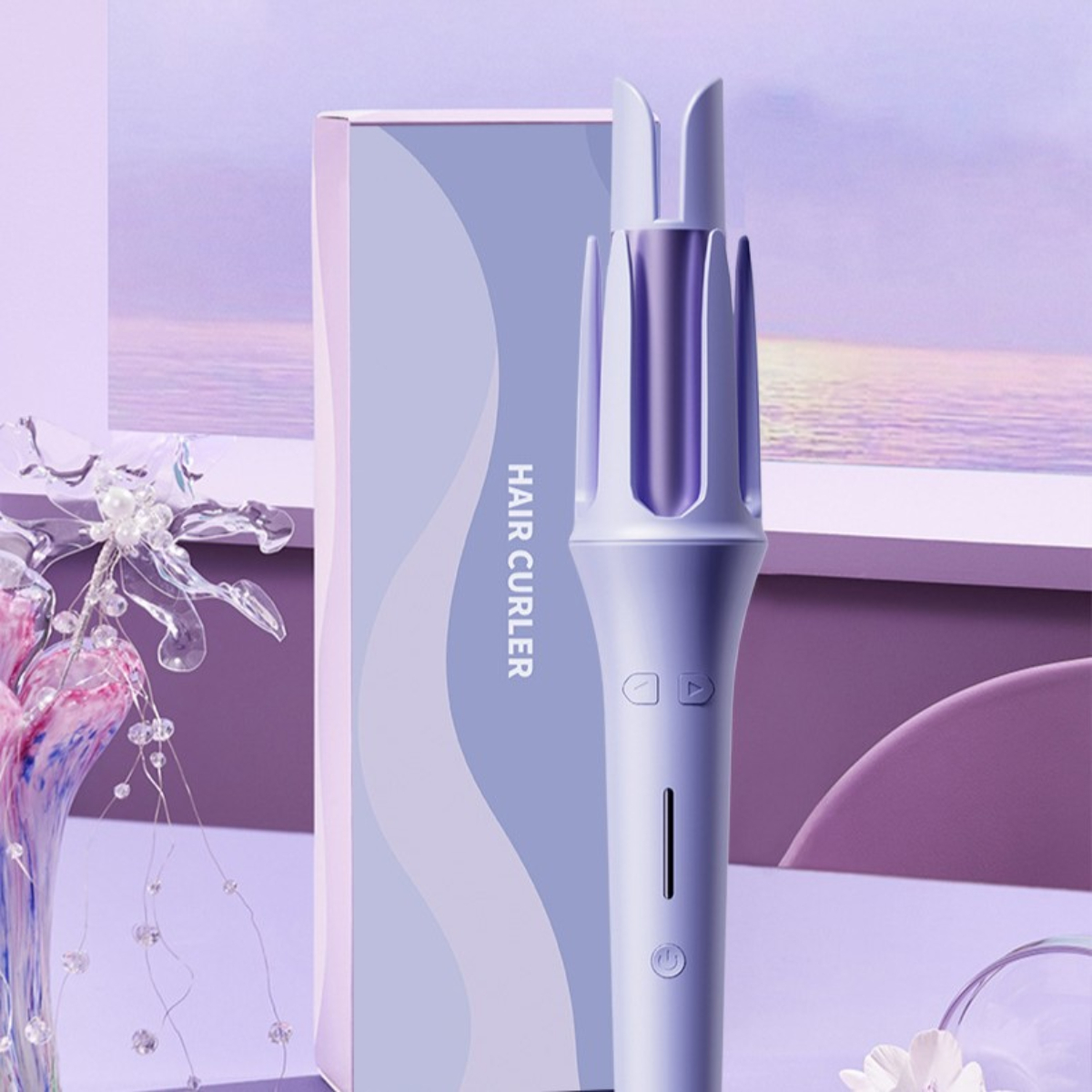 Haar-Lockenstab mit einer Box daneben. Eine Vase mit Blumen im Hintergrund.