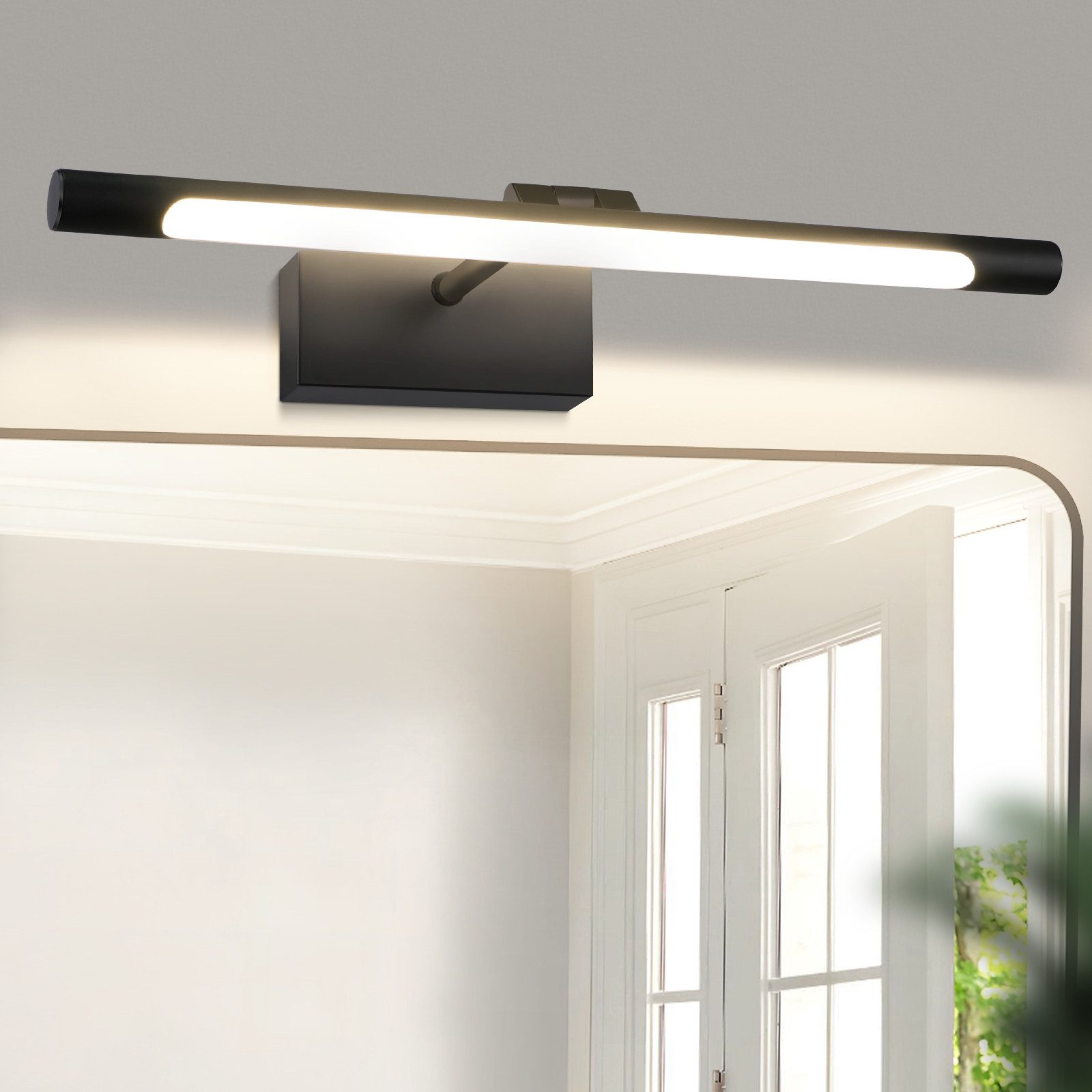 Apparecchio di illuminazione a LED nero sopra uno specchio in una stanza bianca.