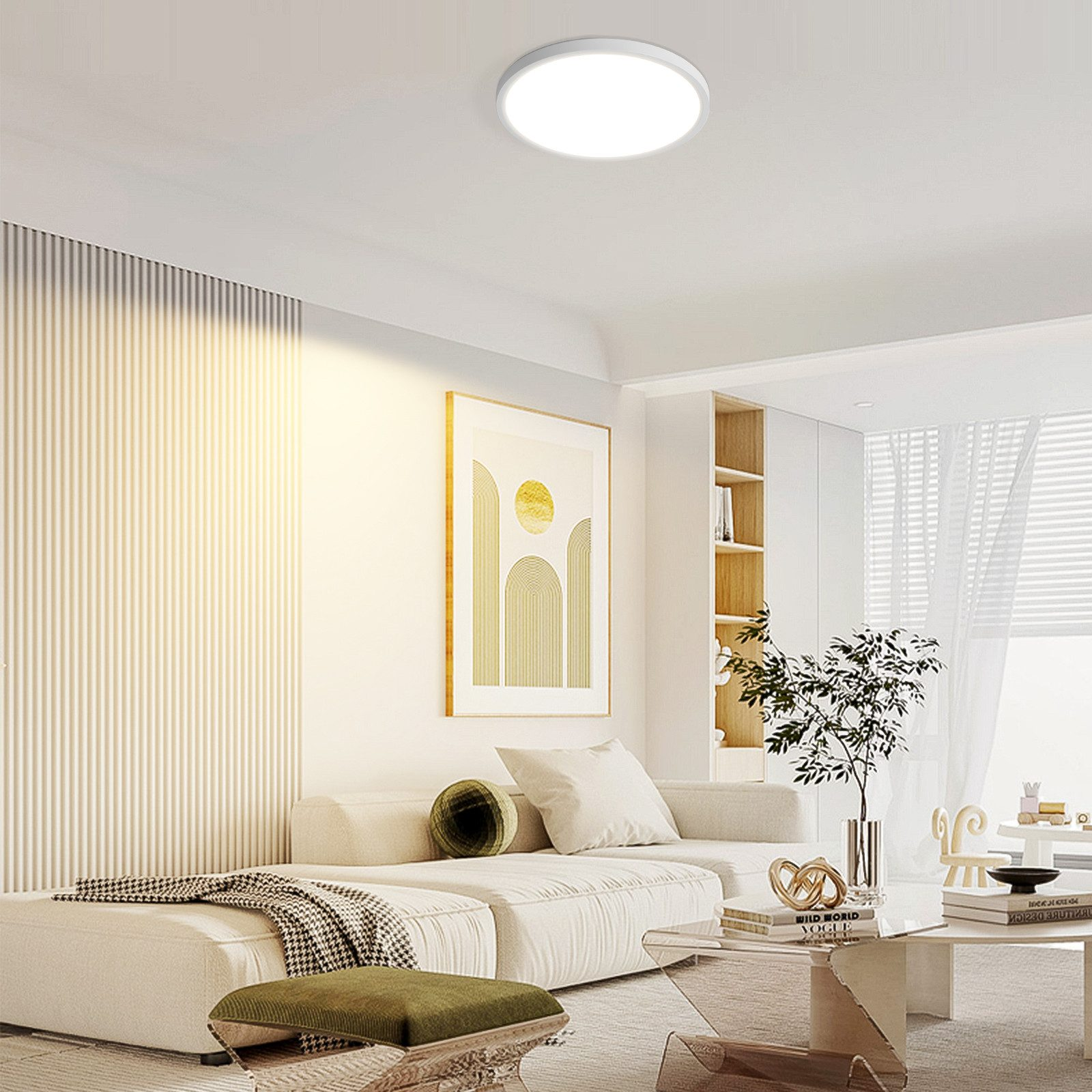 Ein modernes Wohnzimmer mit weißen Sofas, einem Couchtisch und einer runden Deckenlampe.