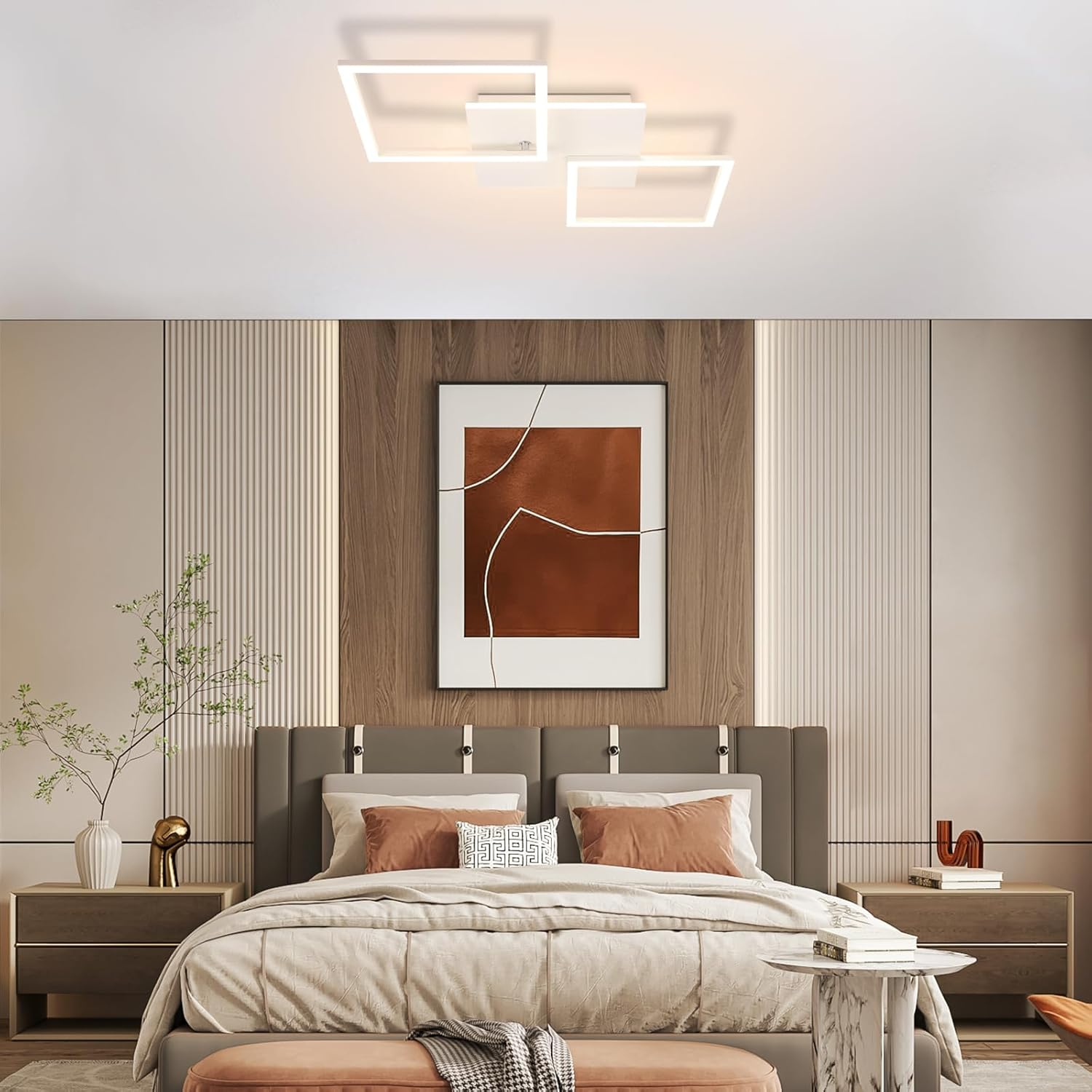 Dormitorio moderno con cama grande, mesitas de noche y pintura. El techo tiene luces rectangulares.