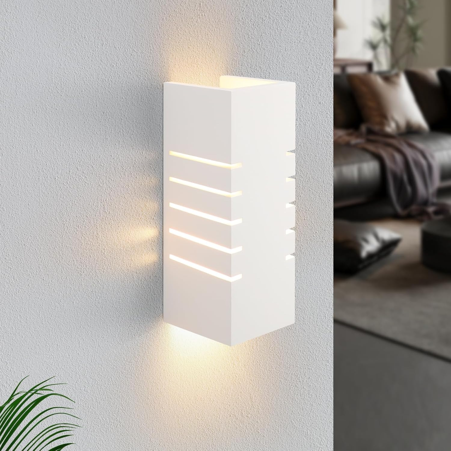 Lámpara de pared blanca con ranuras de luz horizontales. En pared gris. Interior al fondo.
