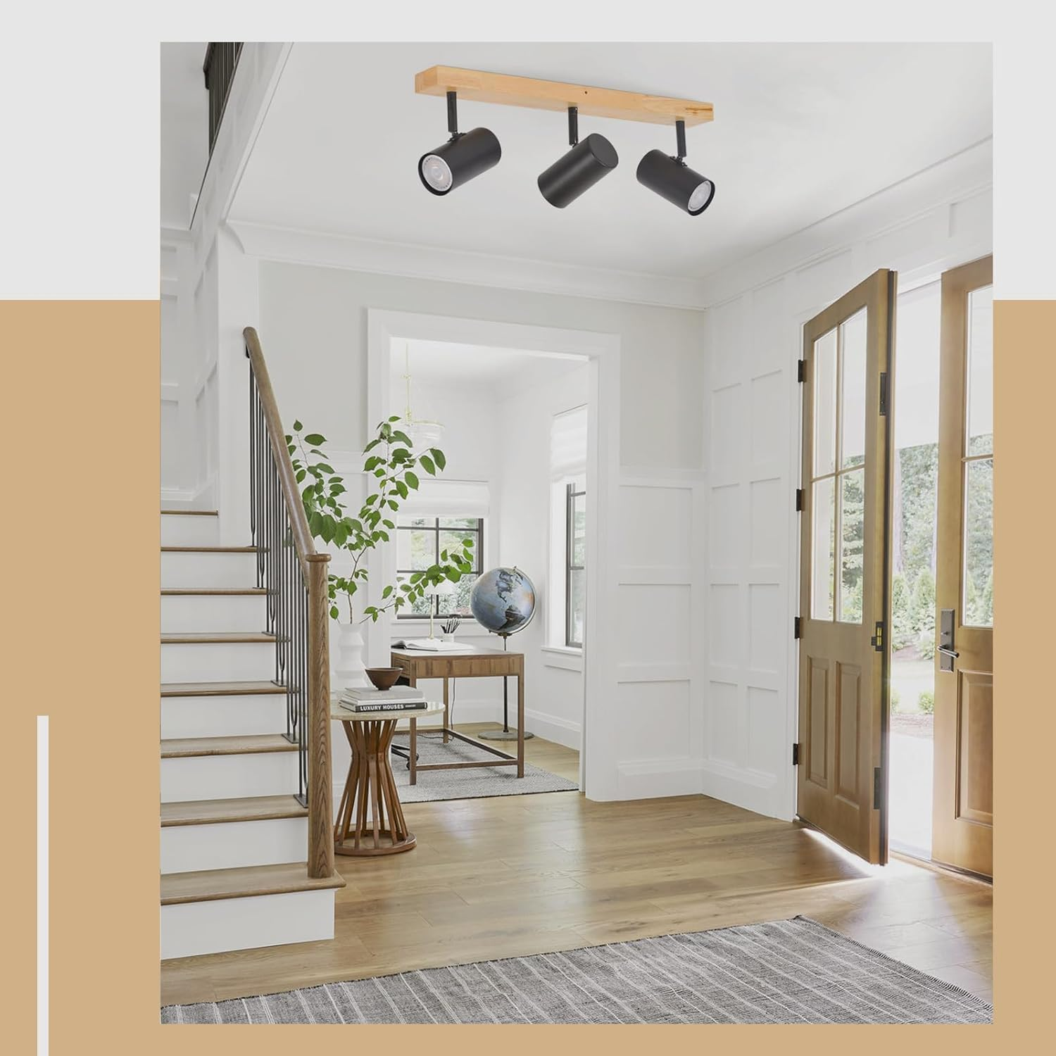Corridoio con scala, scrivania e tre faretti neri sul soffitto.
