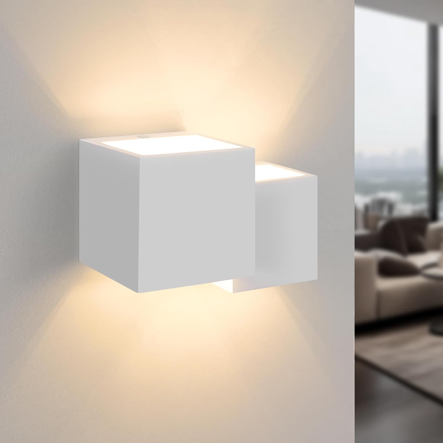 Una lámpara blanca montada en la pared con dos cubos. La lámpara emite luz hacia abajo.