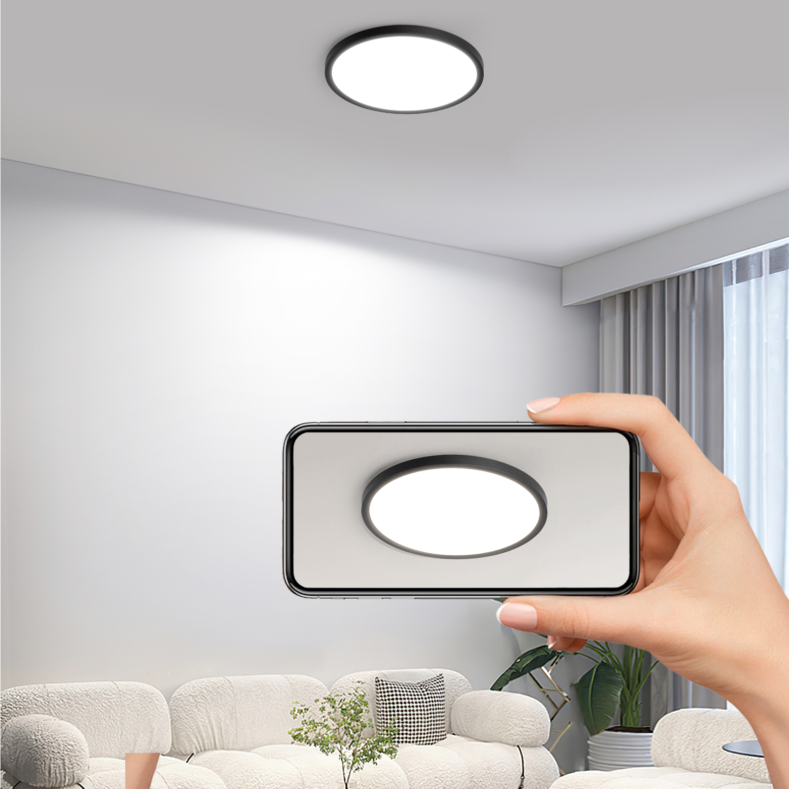 Una mano sosteniendo un teléfono que muestra una lámpara de techo. La luz es negra y circular, y la habitación es blanca.