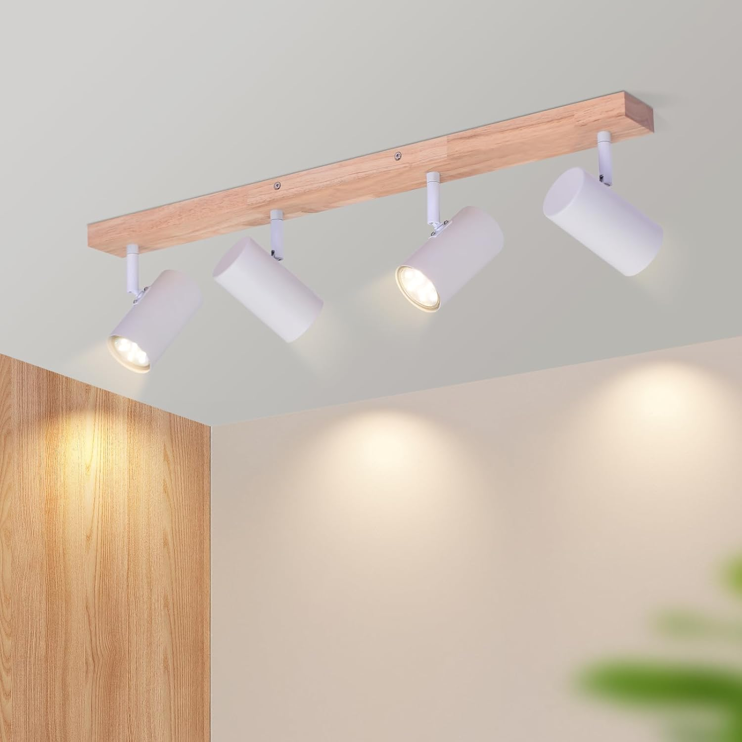Quattro faretti bianchi montati su una trave di legno sul soffitto.
