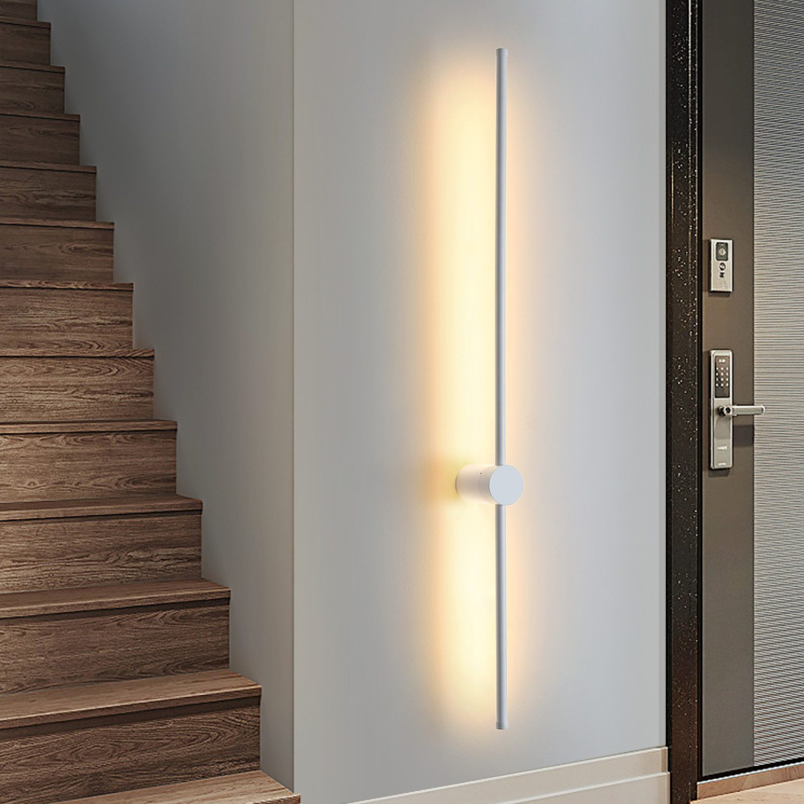 Una moderna lampada da parete bianca con una striscia di luce verticale vicino alle scale.