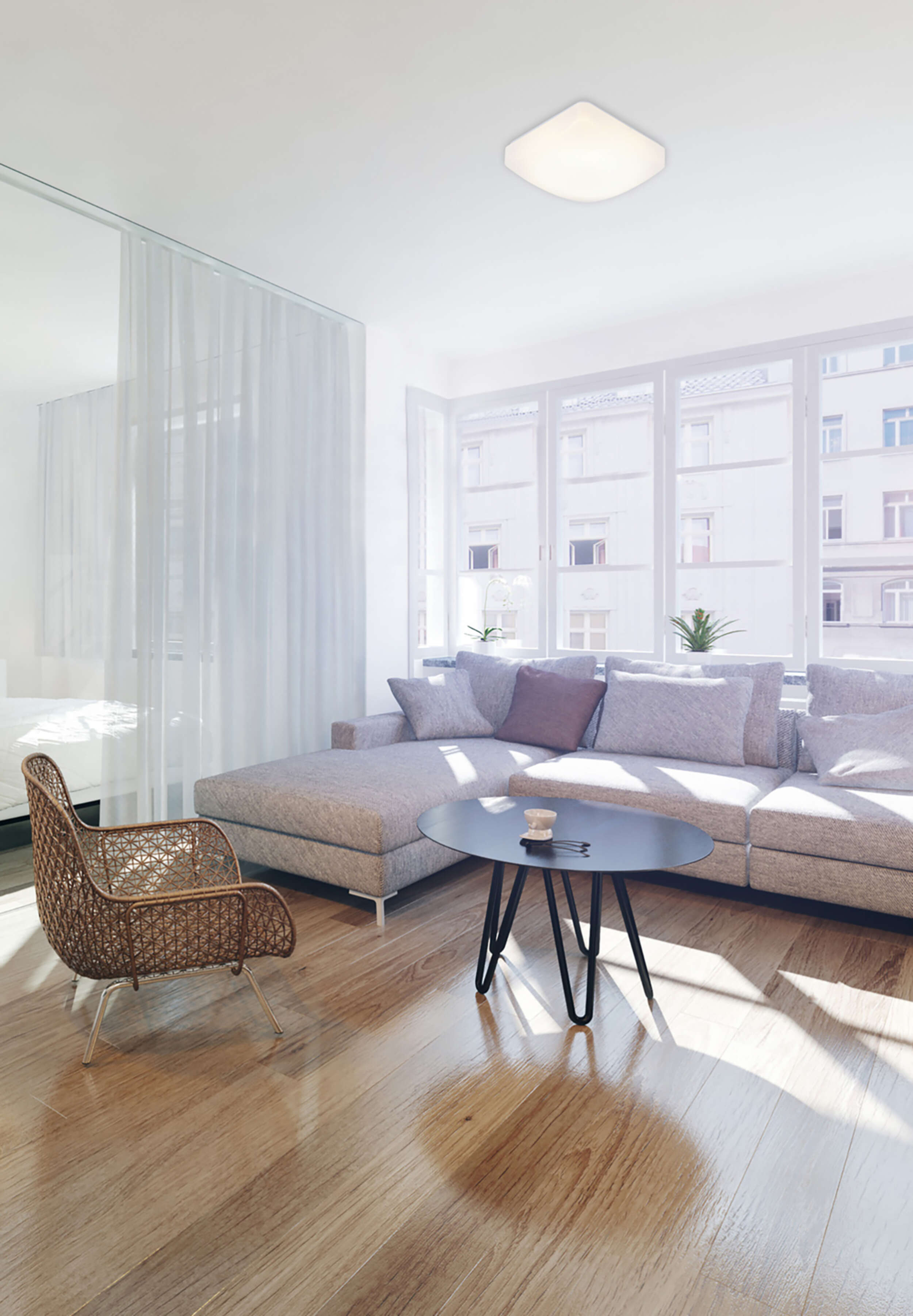 Wohnzimmer mit Sofa, Tisch und Fenster.