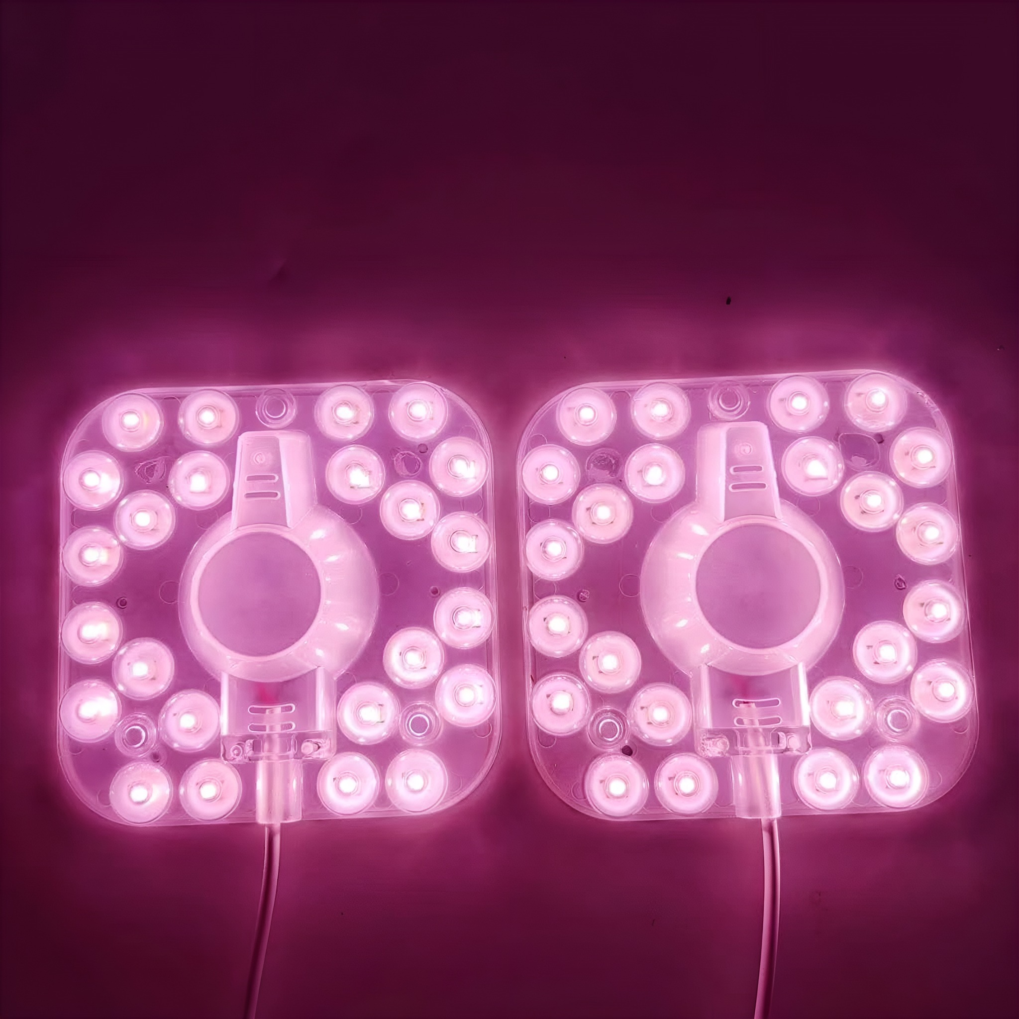 Zwei quadratische LED-Lichtpaneele mit roter Beleuchtung und einem weißen Mittelkreis.