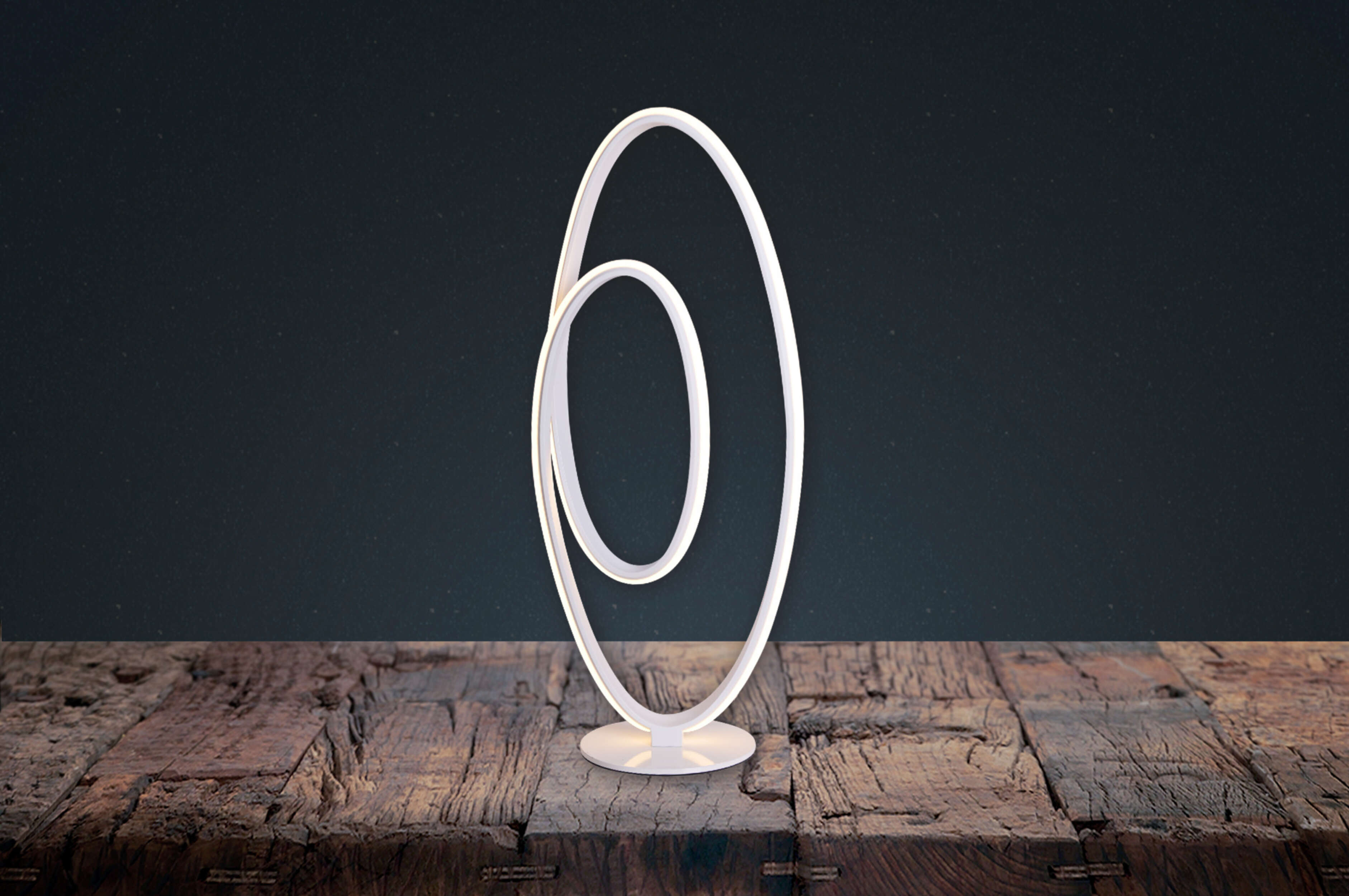 Weiße moderne Lampe auf einem Holztisch. Zwei miteinander verbundene weiße Ovale. Dunkler, gesprenkelter Hintergrund.