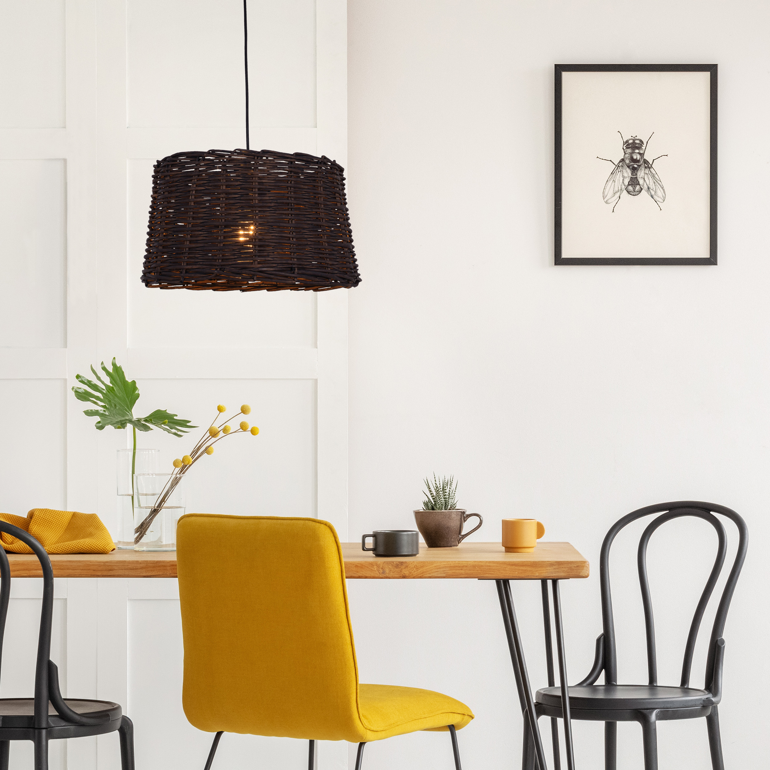 Ein Esszimmer mit Tisch, Stühlen, Pendelleuchte und Kunstwerk.