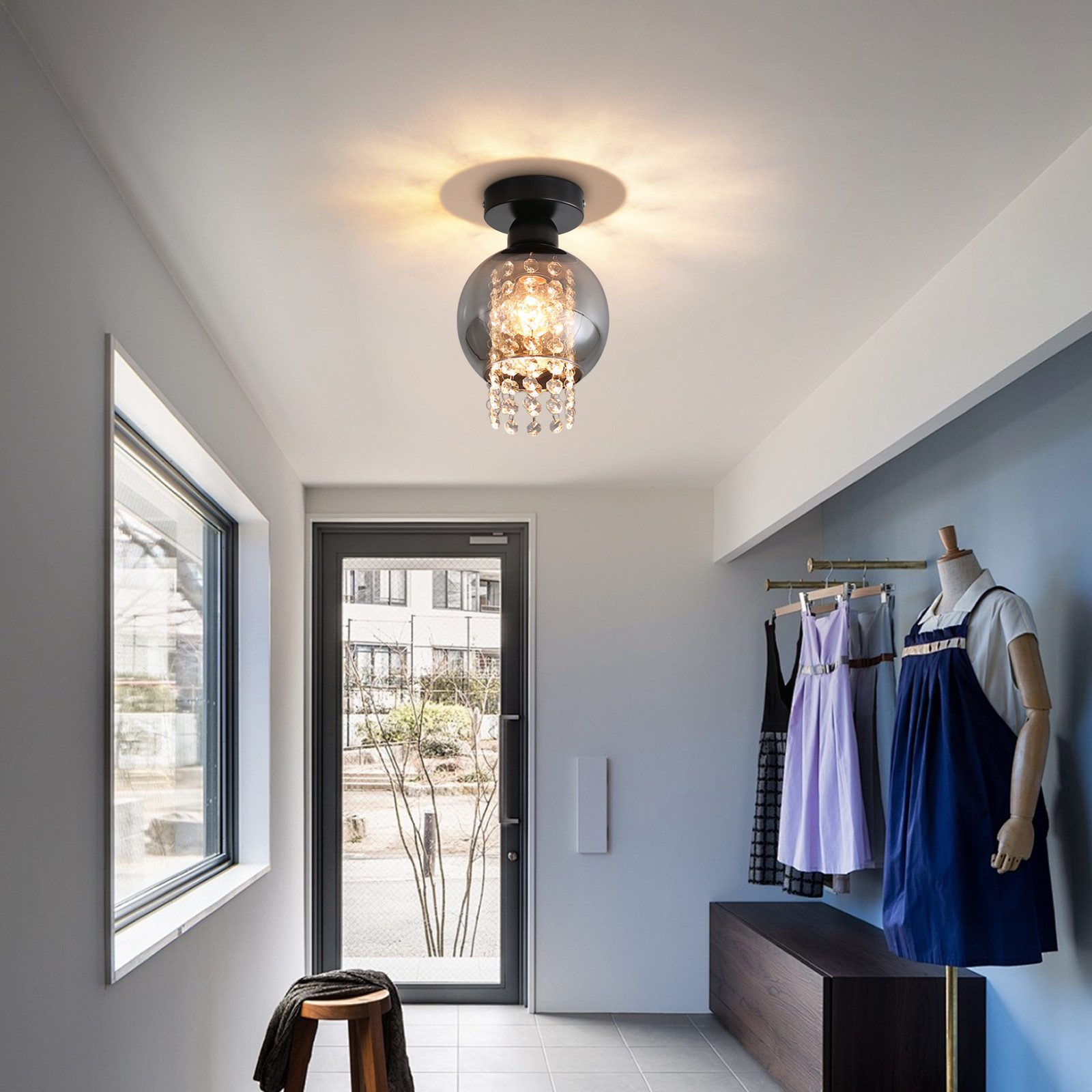 Pasillo con lámpara de techo, puerta, ventana, ropa y taburete.