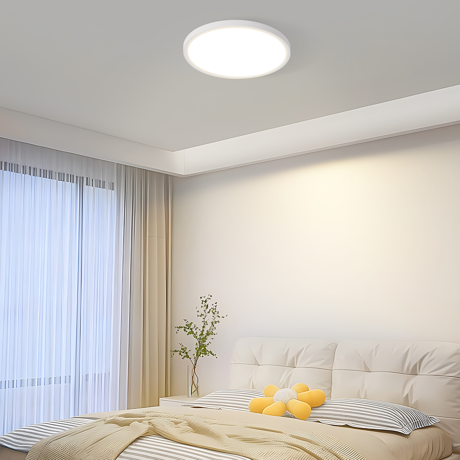 Dormitorio con luz de techo redonda, cama y ventana, creando un ambiente cálido.