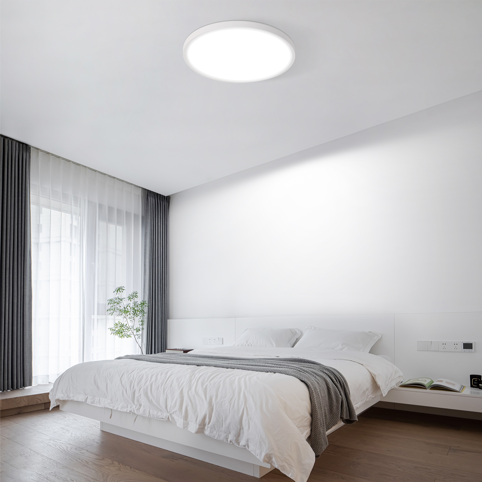 Dormitorio moderno con cama y cabecero blancos, cortinas grises y luz de techo.