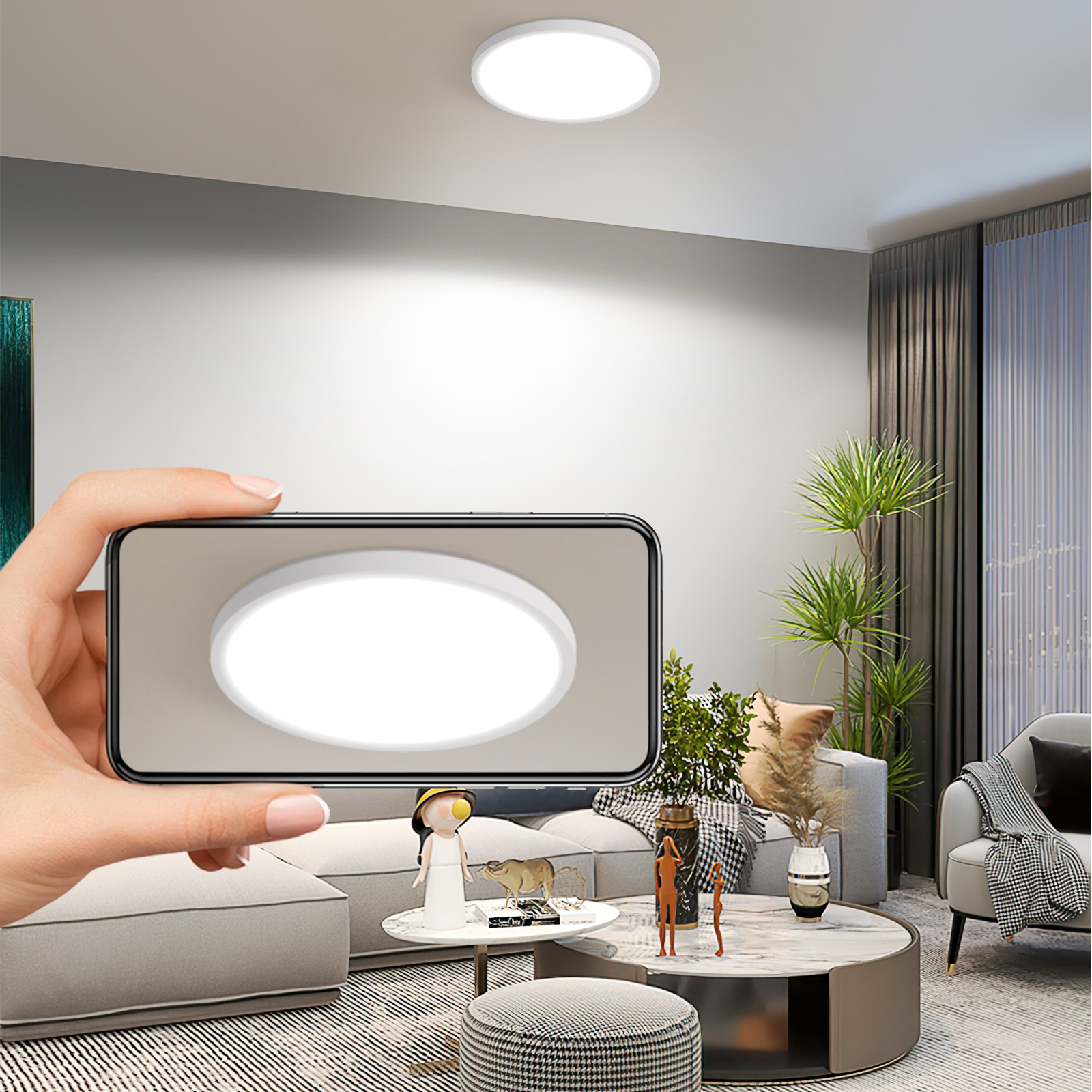 Una mano sosteniendo un teléfono, mostrando una luz de techo. Salón con sofá, planta y una pequeña figura en la mesa.