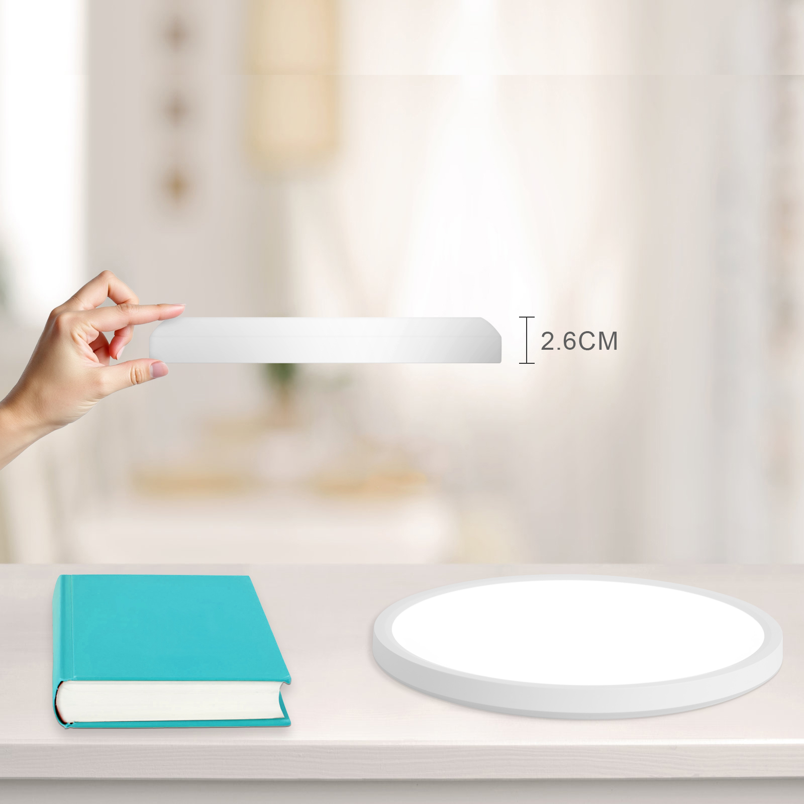 Una lámpara de techo y un libro sobre una mesa. La luz está encendida.