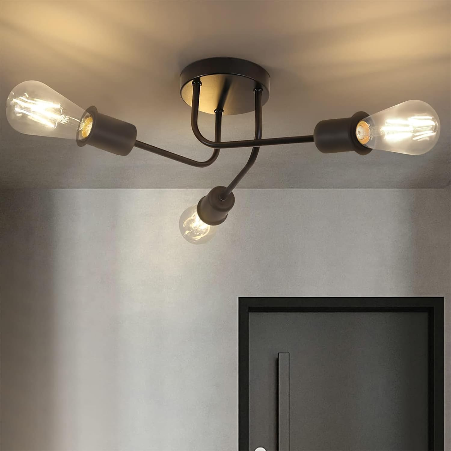 Lampa sufitowa z trzema żarówkami zamontowana na jasnoszarym suficie.