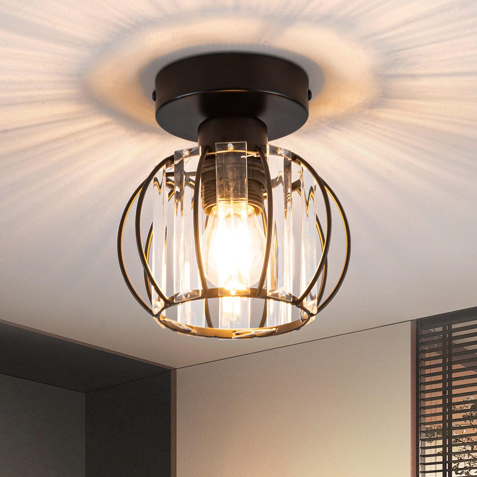 Lampa sufitowa z czarną ramą, szkłem i żarówką.