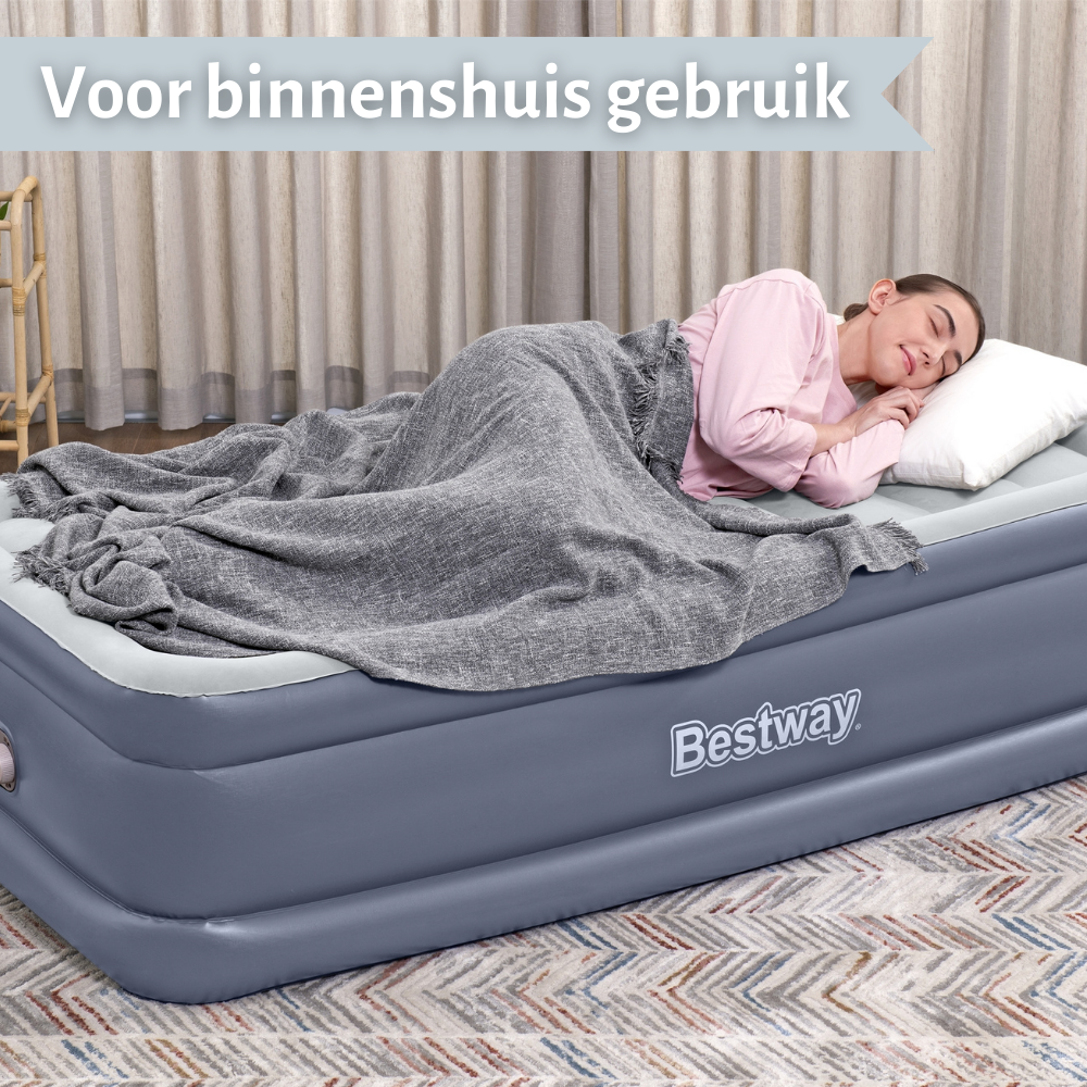 Een vrouw die slaapt op een grijs luchtbed in een kamer. Tekst: Voor binnengebruik.