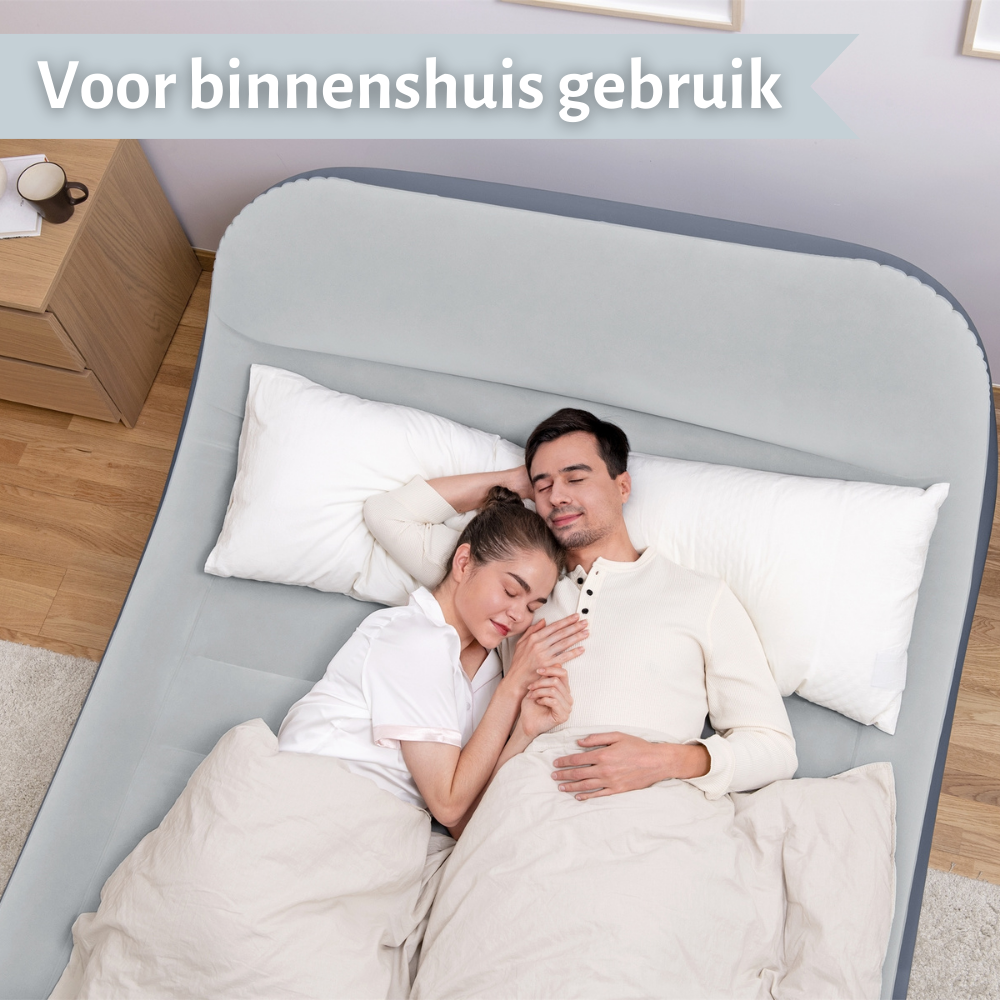 Koppel slaapt op een opblaasbaar bed. Nachtkastje met boek en kopje is zichtbaar.