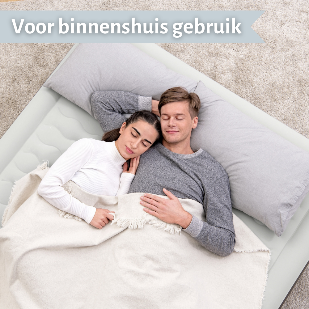 Un couple dormant sur un lit. Un long oreiller derrière leur tête, recouvert d'une couverture.