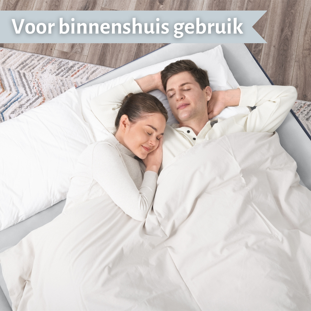 Een stel slaapt op een opblaasmatras. Een witte deken en kussens liggen op de matras. Binnen.