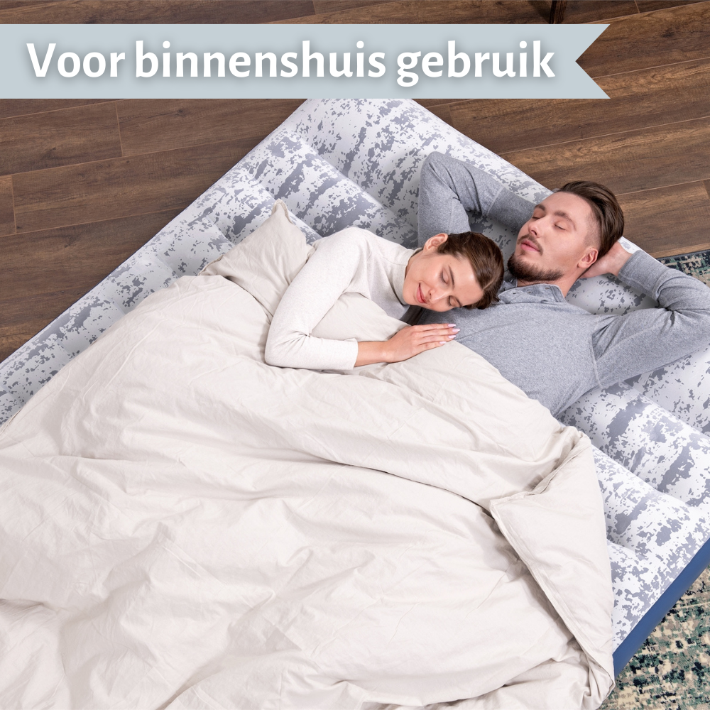 Couple dormant sur un matelas gonflable. Le matelas a un dessus à motifs et est dans un cadre intérieur.