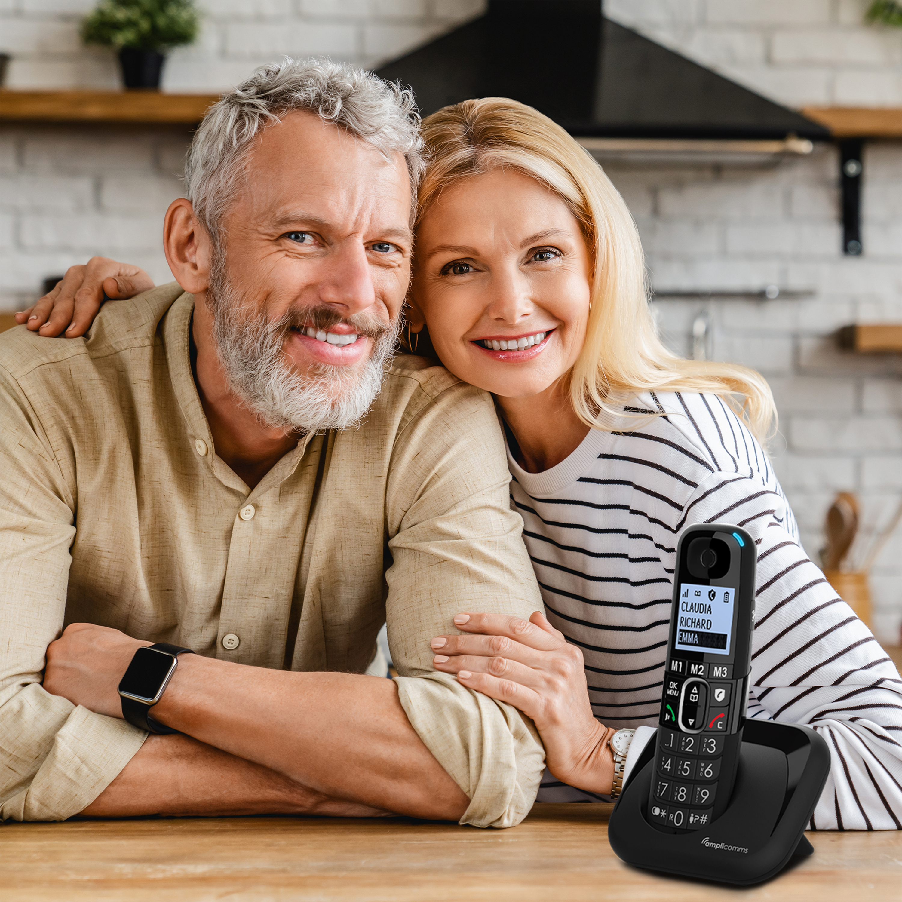 Koppel, lachend met draadloze telefoon op tafel.