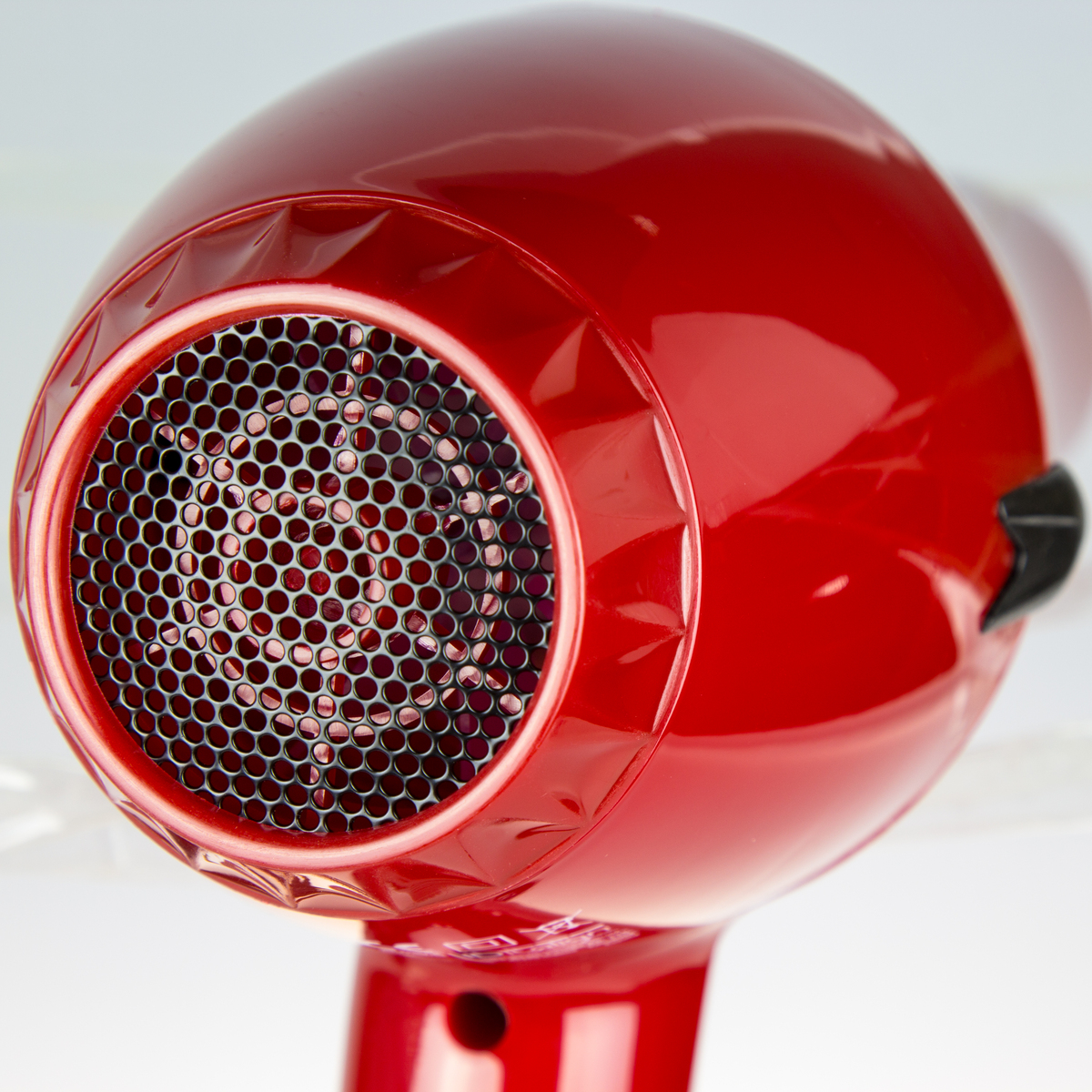 Czerwona suszarka do włosów, zbliżenie na przód z czarną siatką.