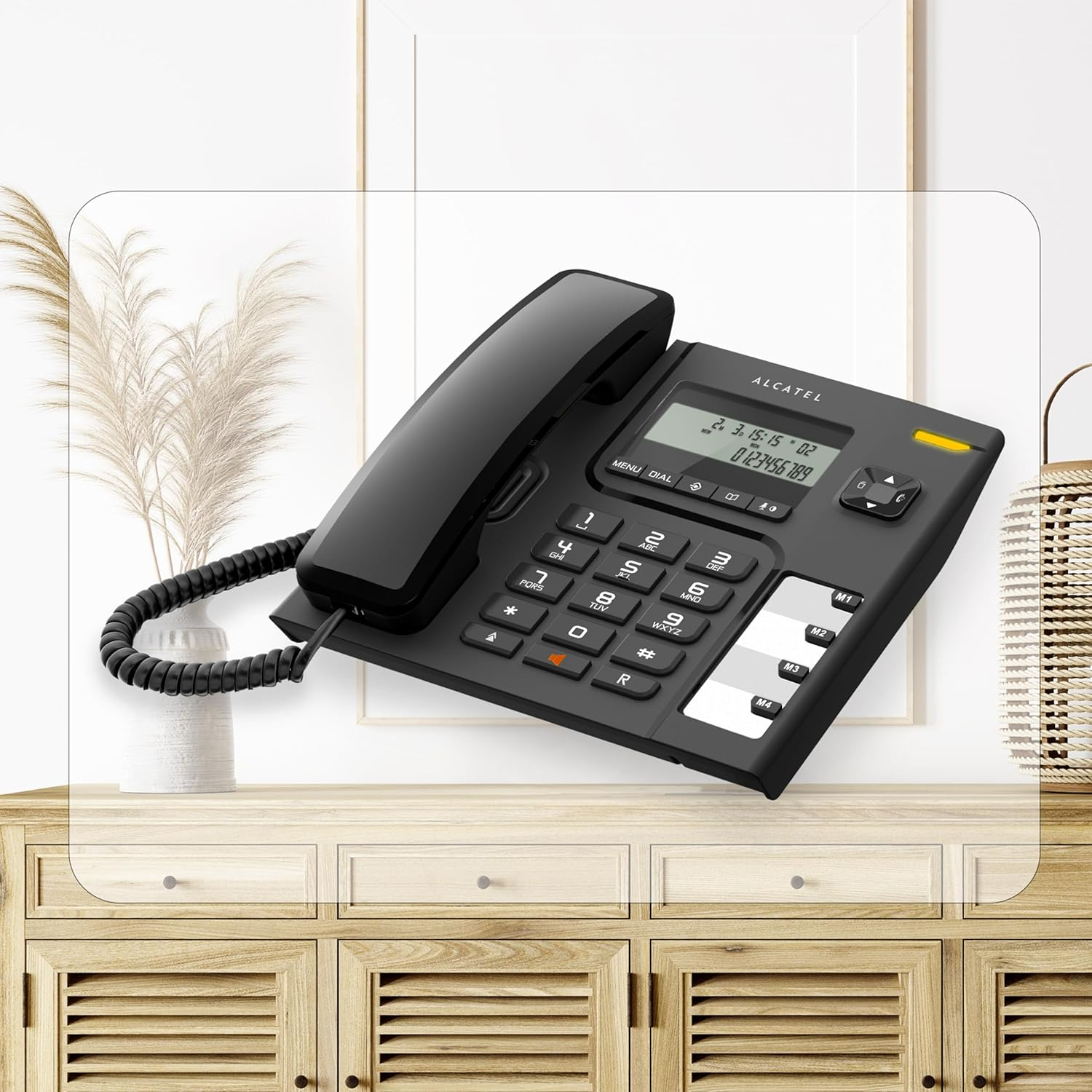 Czarny telefon stacjonarny Alcatel na drewnianej szafce z przezroczystym ekranem.