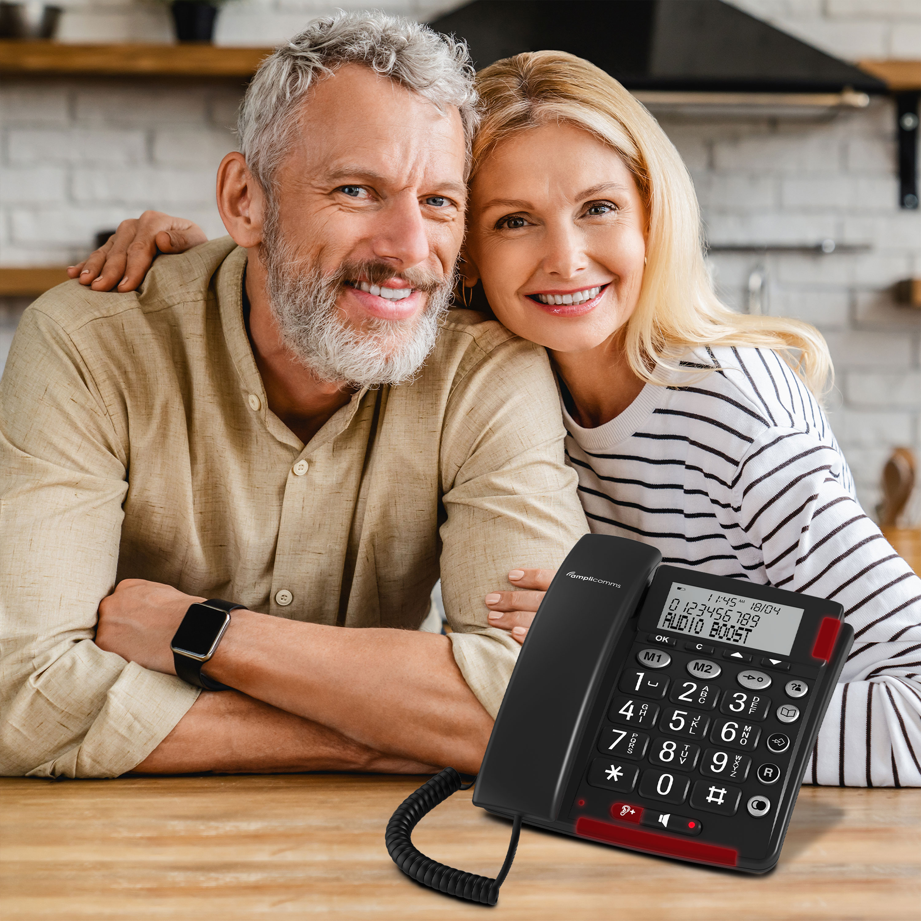 Coppia felice sorridente, donna bionda, uomo con capelli grigi, telefono fisso.