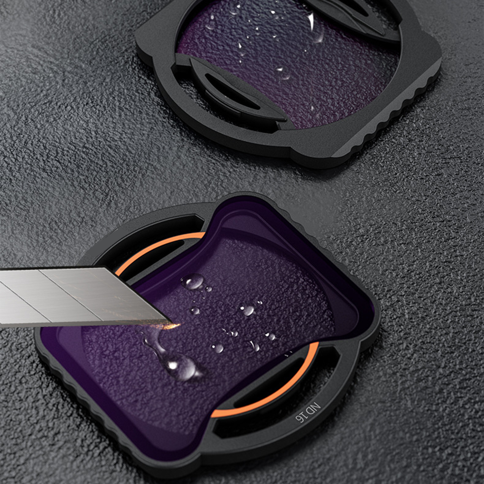 Zwei Filter, mit einem Messer, das einen lila Filter schneidet. Wassertropfen befinden sich auf dem Filter.