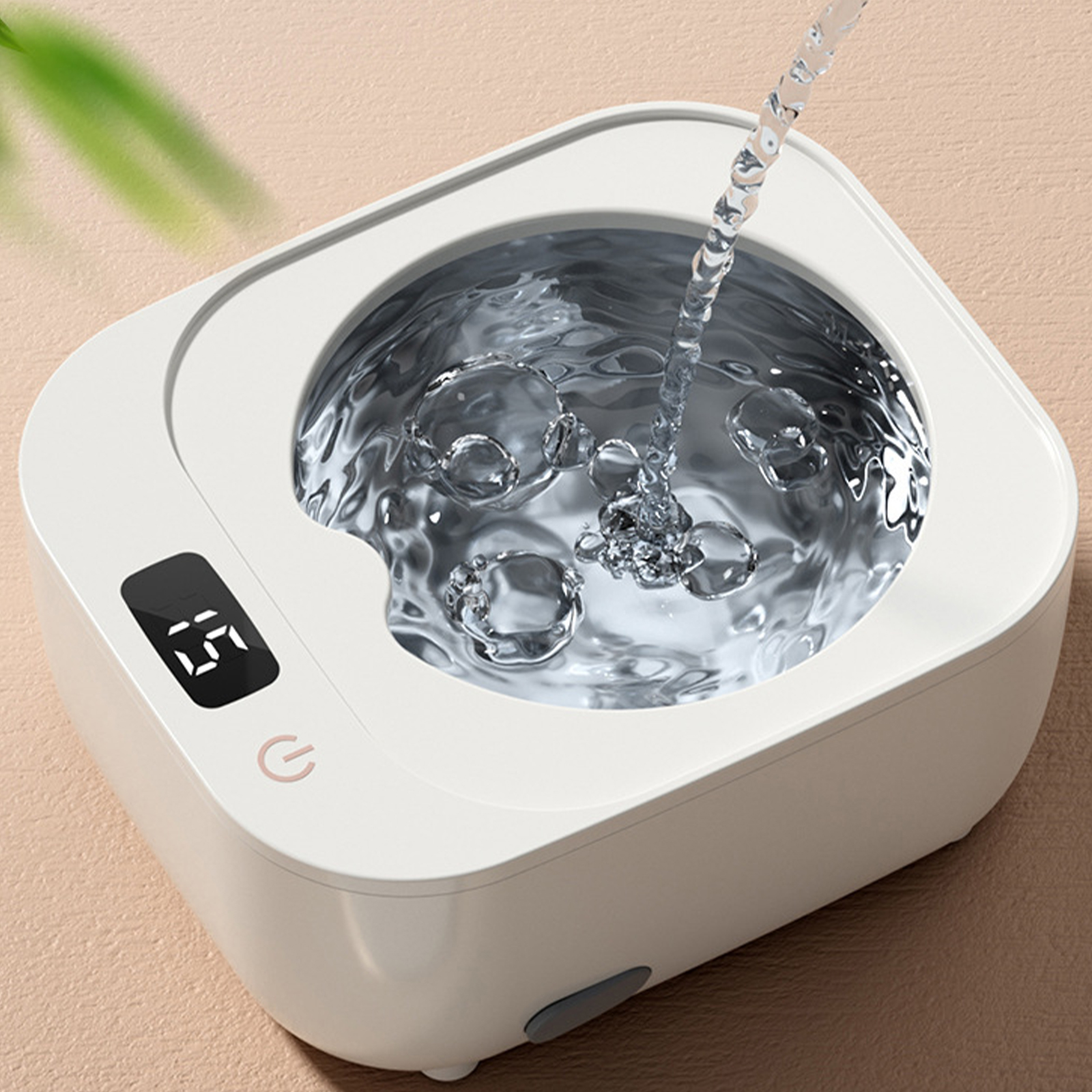 Ein weißer Ultraschallreiniger mit Digitalanzeige und Wasser, das eingegossen wird.