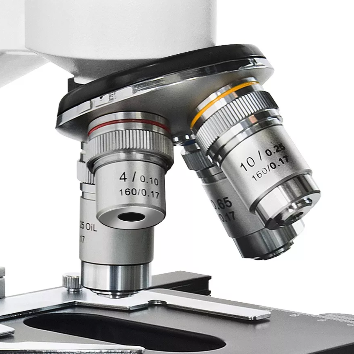 Un microscopio con tres lentes de objetivo. Dos están angulados y uno recto. El fondo es blanco.