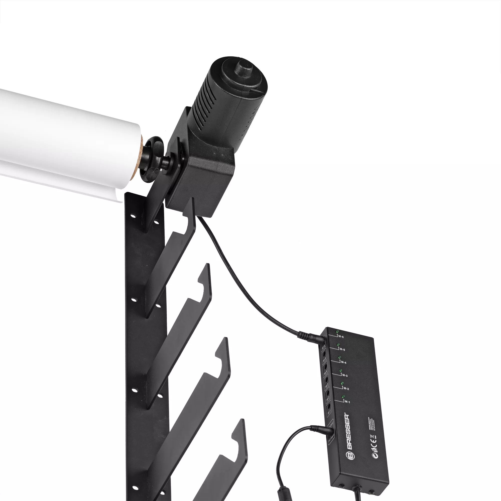 Estante de metal negro que sostiene un rollo de papel blanco. Un dispositivo negro con cables está conectado.