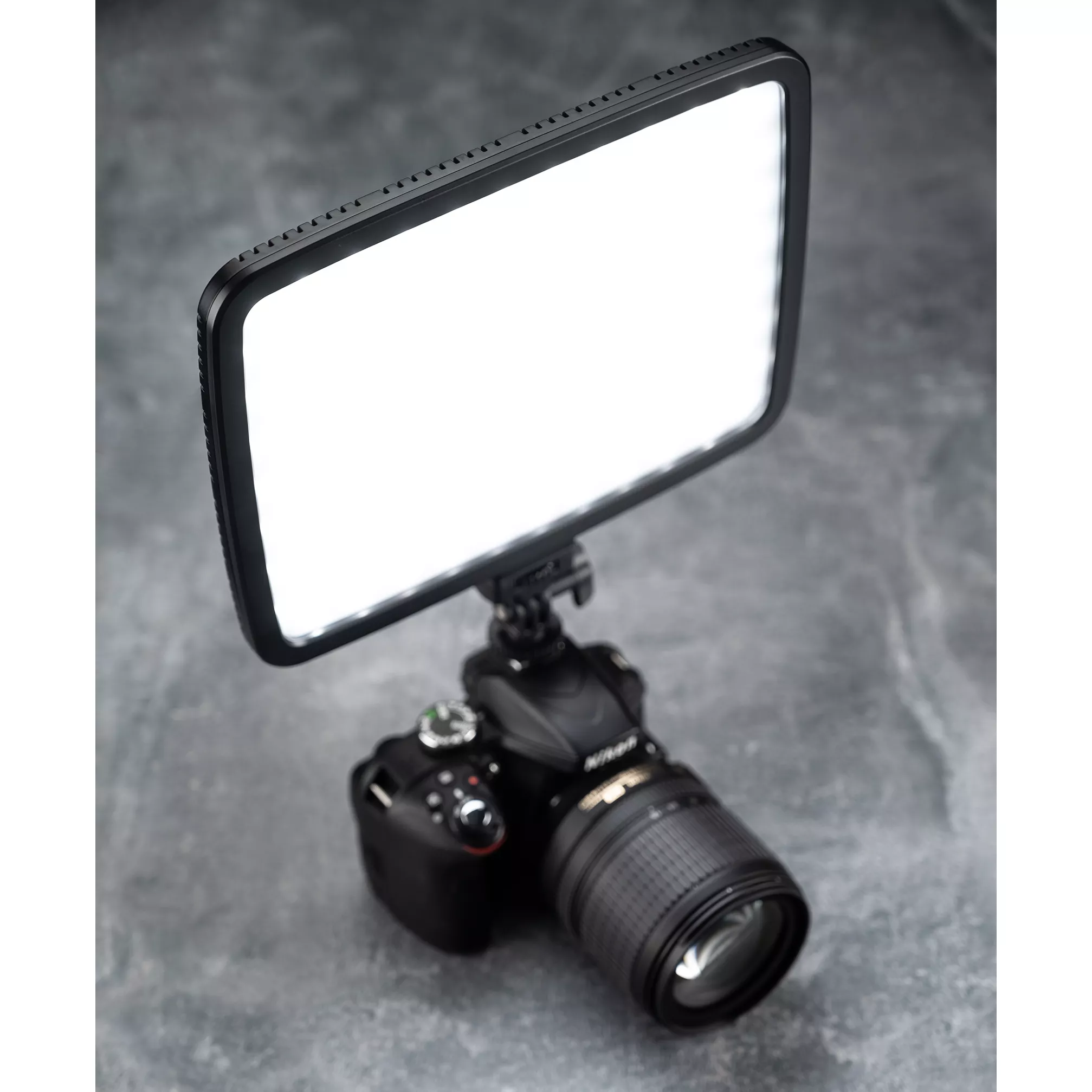 Camera with a bright LED light attached, showing a black camera body.