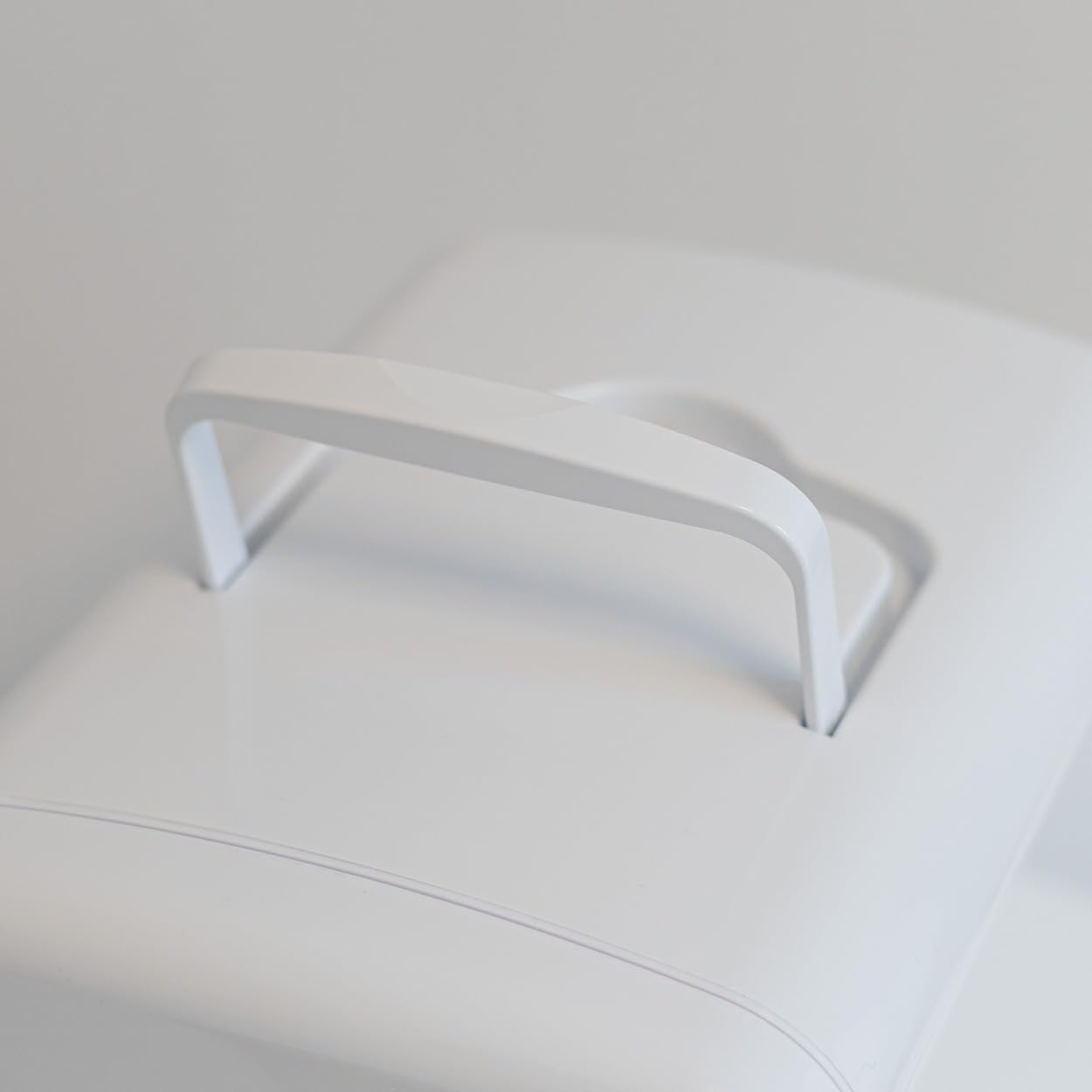 Un asa de plástico blanco sobre un contenedor de plástico blanco.
