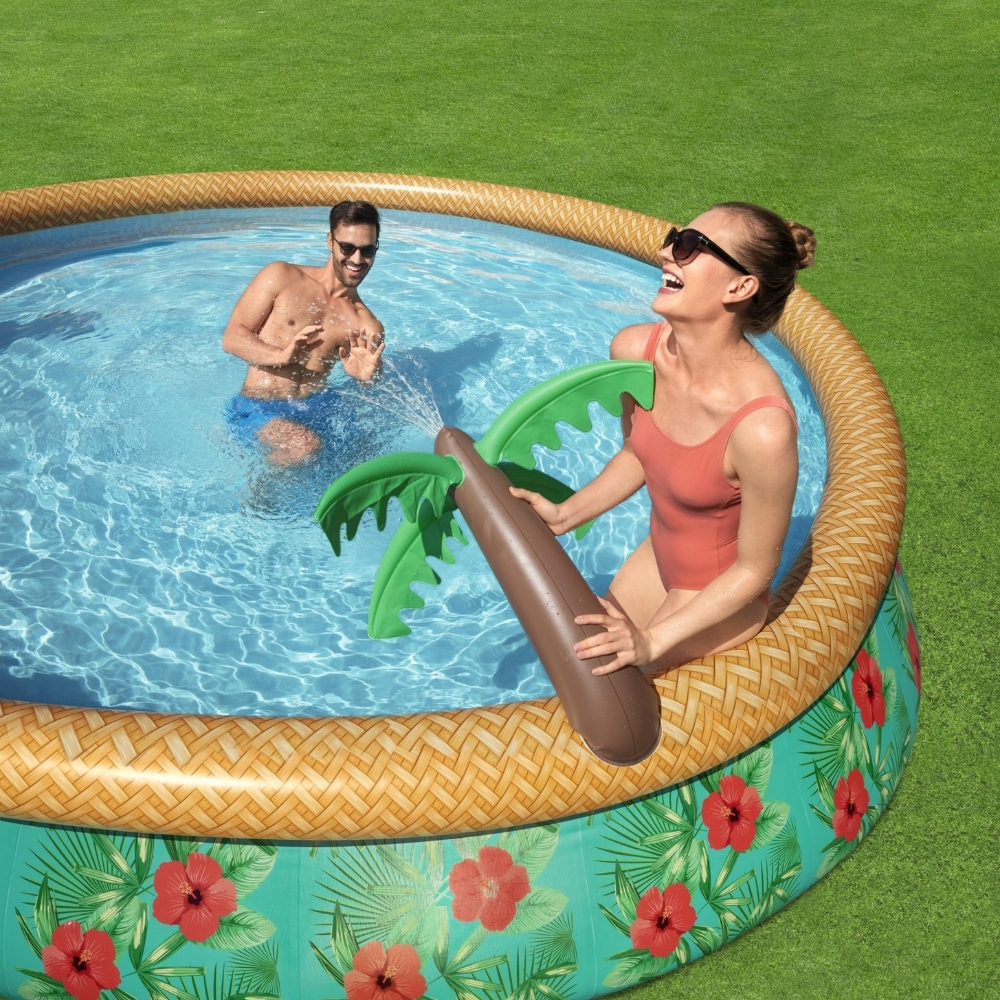 Personnes dans une piscine avec un pulvérisateur d'eau en forme de palmier.