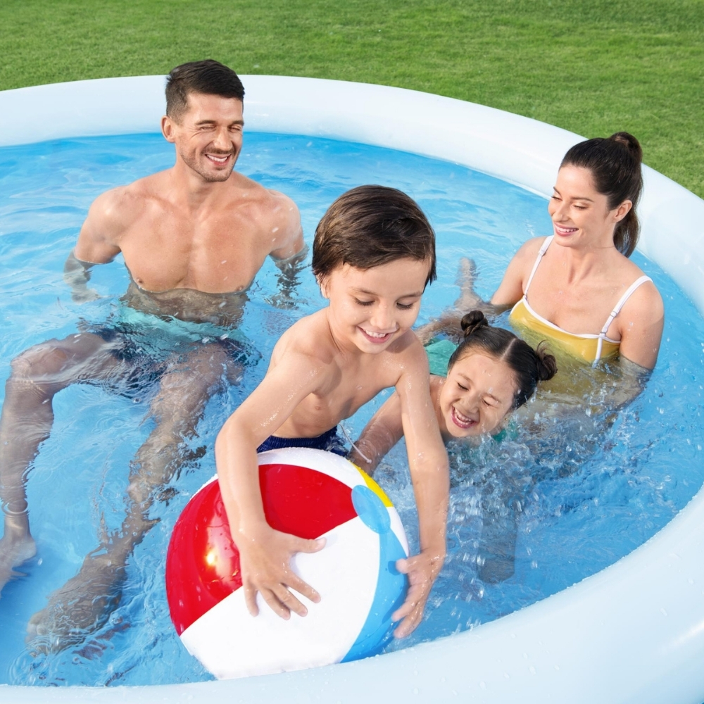 Une famille dans une piscine jouant avec un ballon de plage.