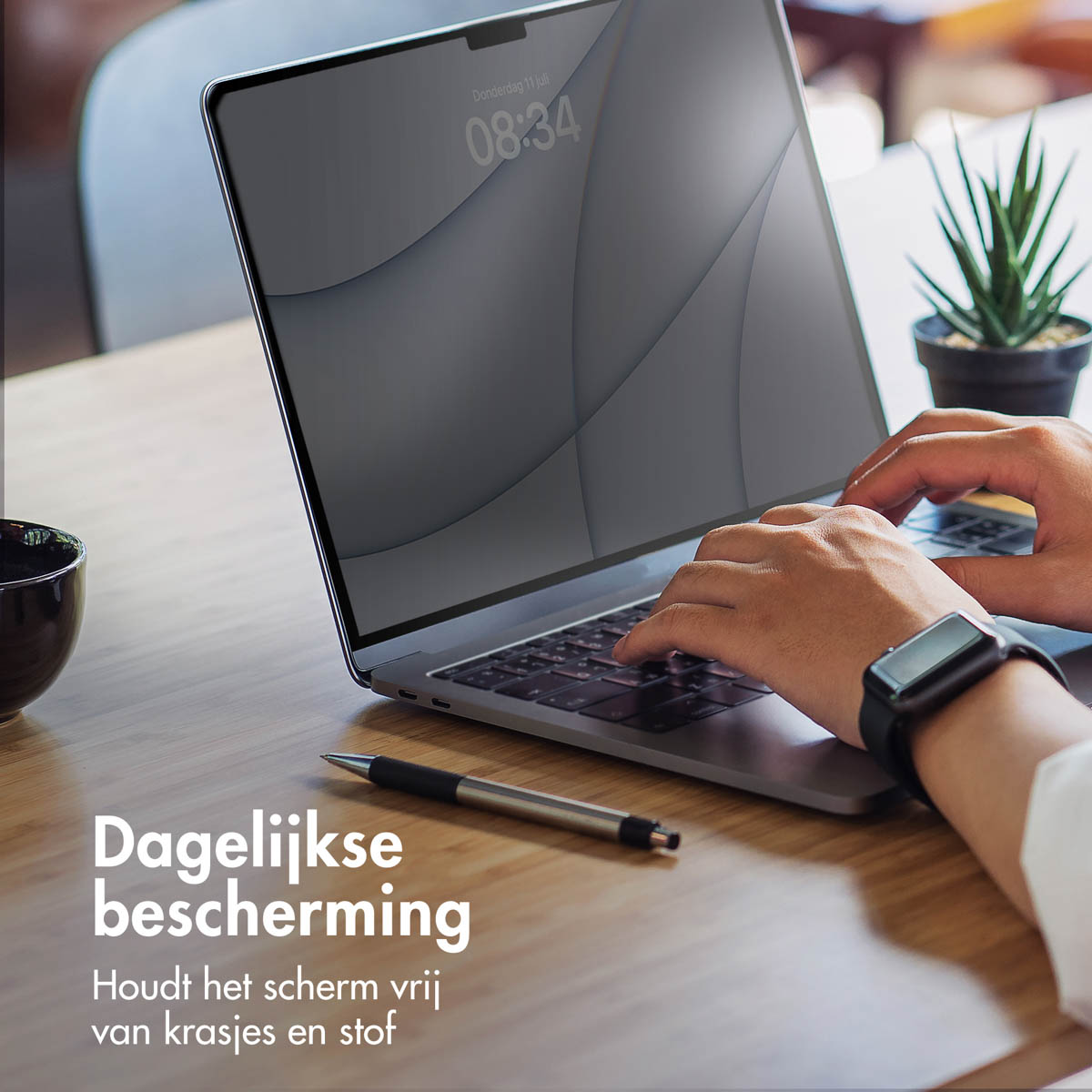 Persoon typt op een laptop. Horloge om de pols. Houten tafel. Tekst: Dagelijkse bescherming.