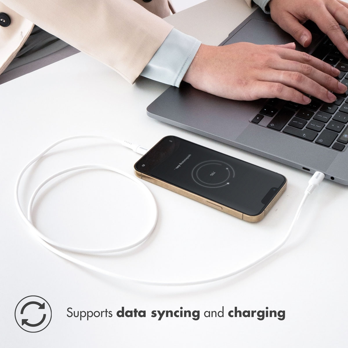 Téléphone en charge avec un câble blanc connecté à un ordinateur portable. Le téléphone affiche 73%.