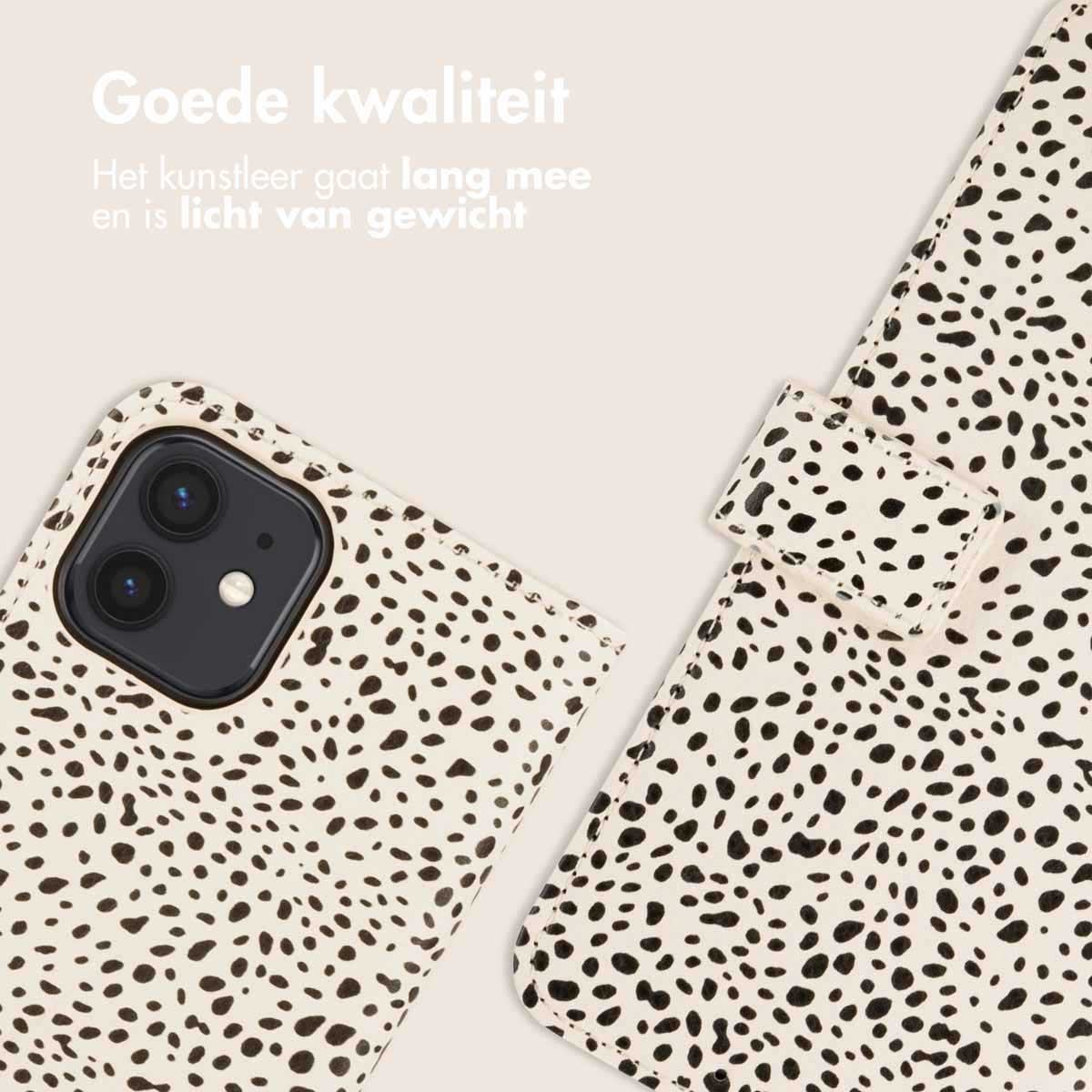 Close-up van een telefoonhoesje. Het heeft een crèmekleurige achtergrond met zwarte vlekken en een telefoonhoesje eraan bevestigd.