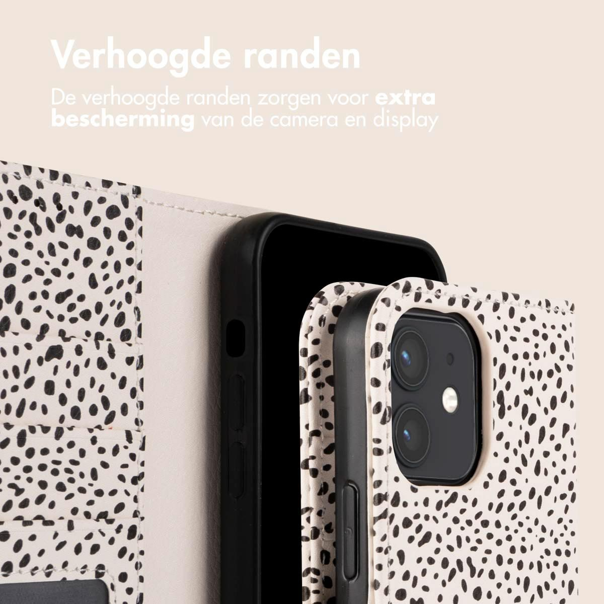 Telefoonhoesje. Een witte hoes met zwarte stippen is open. De zwarte telefoon zit erin.