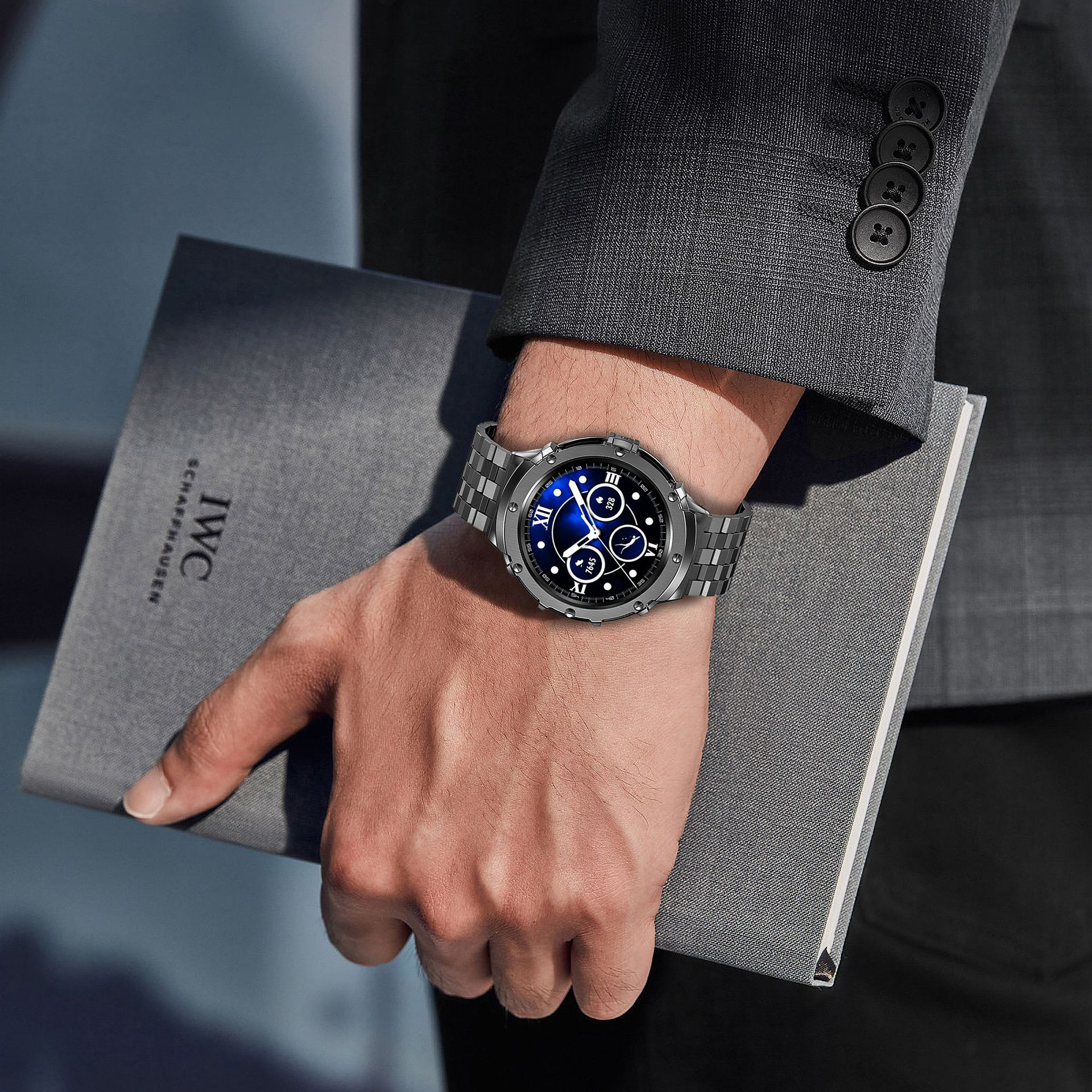 Hand mit Uhr h ält graues Notizbuch. Verschwommener Bürohintergrund.
