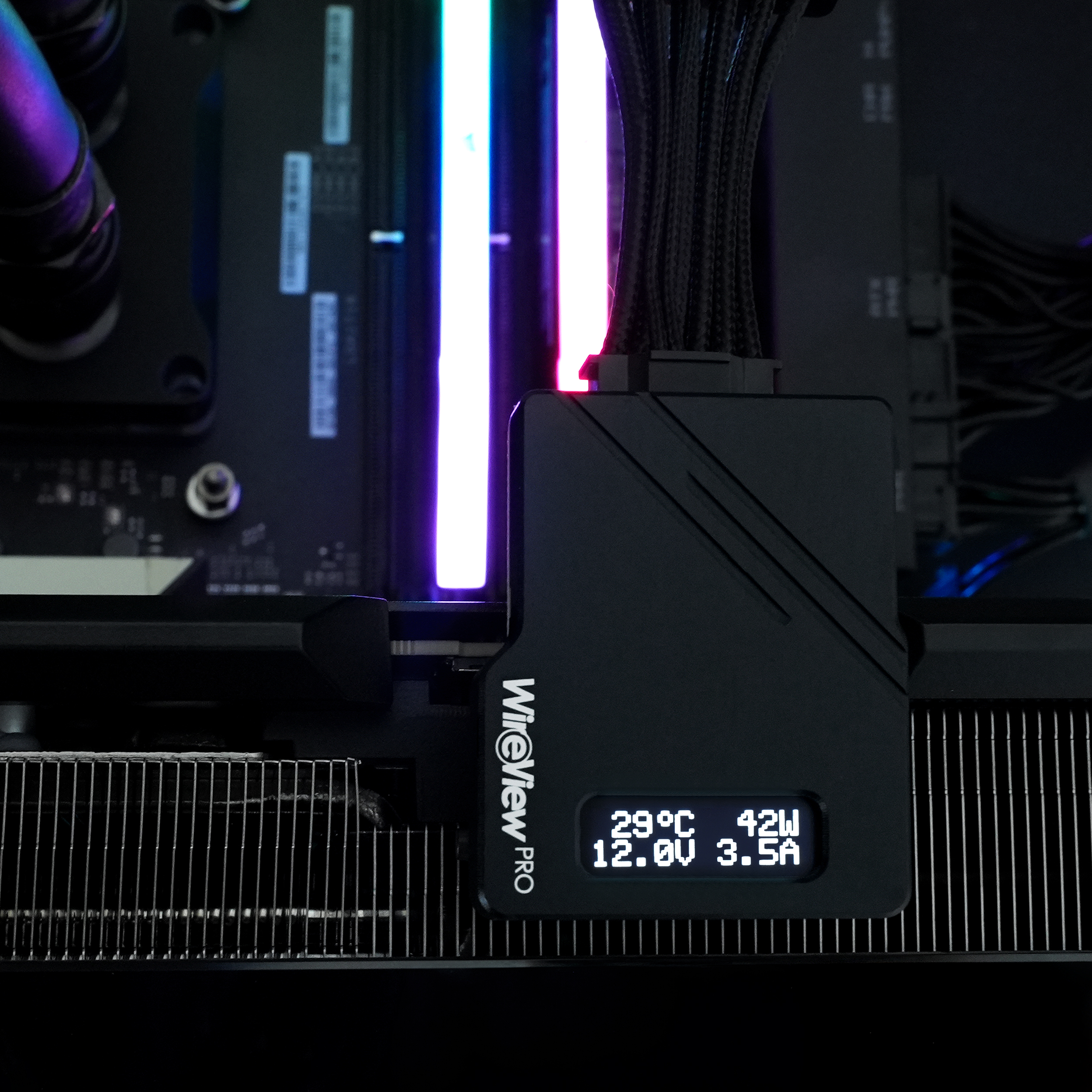 Ein schwarzes Gerät mit Temperatur- und Leistungsanzeigen, verbunden mit PC-Komponenten.